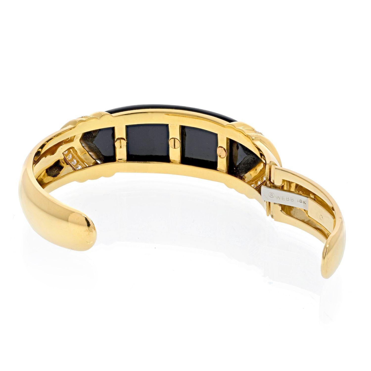 Of hinged design this is a great bracelet that easily goes from day to night this is what we think about this understated David Webb cuff. Made of 18K Yellow Gold set with one fluted onyx panel in the middle, and flanked by 22 round brilliant cut