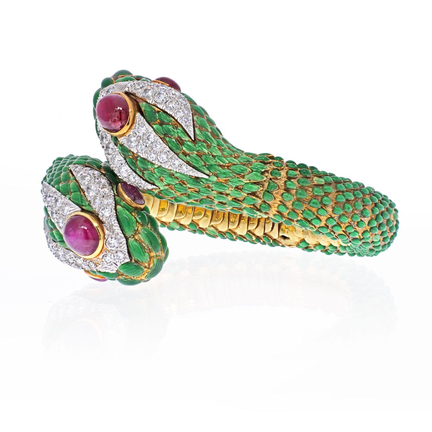 David Webb crossover bangle, designed as a green enamel double-headed snake, each with cabochon ruby eyes, accented by a circular-cut pavé-set diamonds, mounted in platinum and 18k gold. 
Wrist size 8 to 8.5 inches. Some wear to enamel. 
