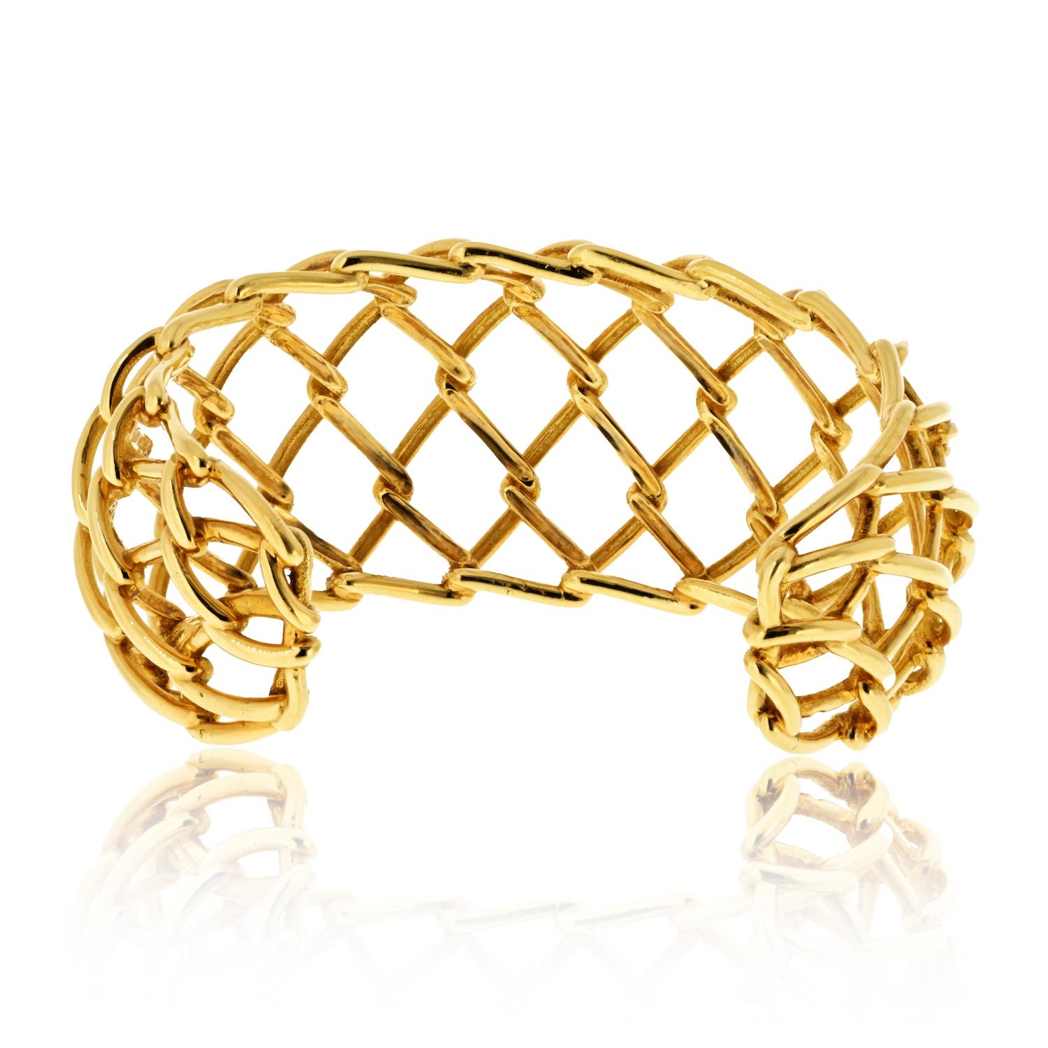 This elegant David Webb 18K yellow gold weave cuff bracelet showcases a light and airy openwork design, creating a striking 