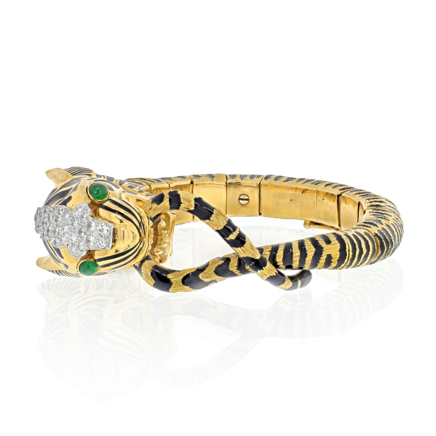 A stunning bracelet by David Webb from the Kingdom collection!
Tiger bracelet that is mostly made in 18k yellow gold with black enameling accross his body as stripes and diamond collar around his neck. 
His eyes are mounted with green emeralds and