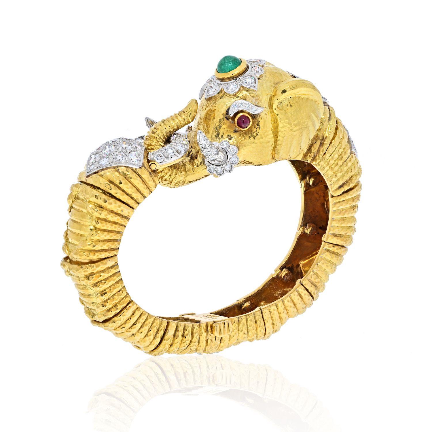 This fabulous and impressive bracelet is a re-take of David Webb#s famed Indian-inspired jewels of the 1920s. The 18k gold elephant set with beautiful diamonds and a green emerald a top his head and rubies as his eyes. 
Tap into your inner animal