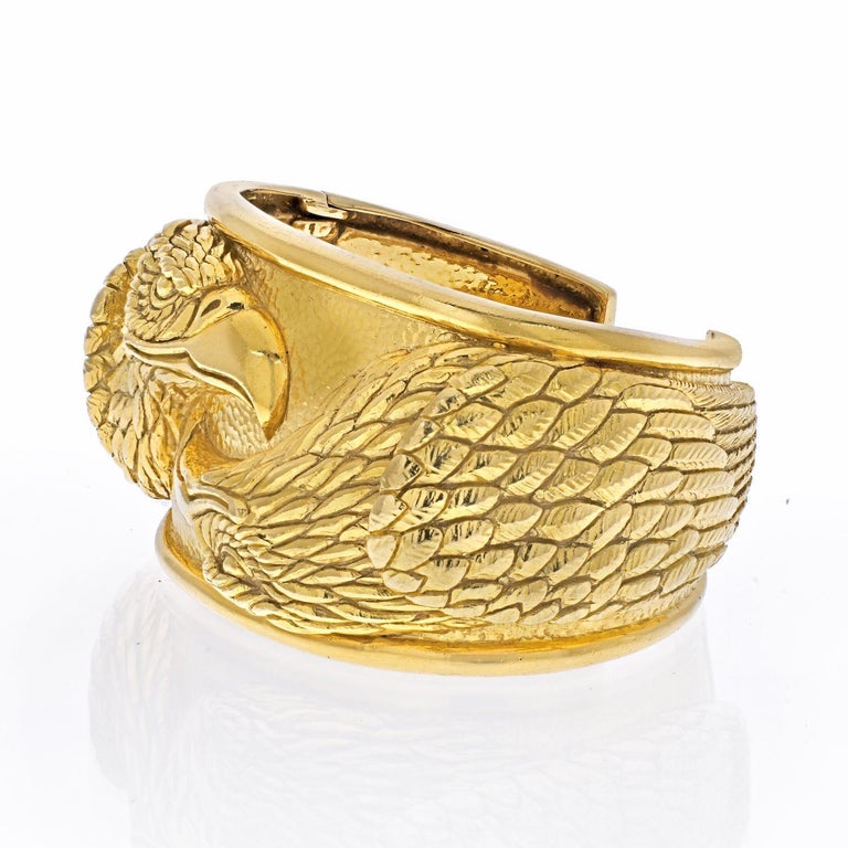 Stunning David Webb 18K Yellow Gold Double Head Eagle Cuff Bracelet. 
This bracelet is designed in hammered and sculpted 18k gold as two opposite eagle heads.
This bracelet is designed as a cuff with a snap closure.
Diameter: 2 1/4 inches. 
Wrist