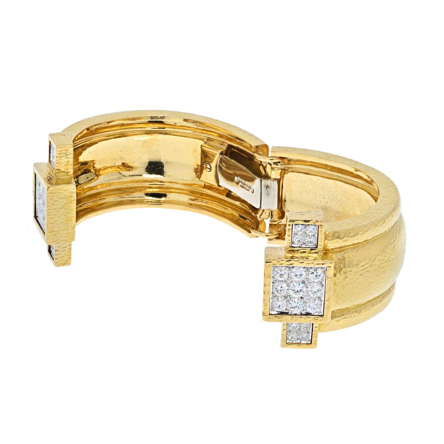 David Webb's diamond cuff bracelet, crafted in polished hammered 18k yellow gold, clamper design, with ends accented with enclosed round brilliant cut diamonds, pave set in Platinum.
Bangle width: approx. 1 inch. 
Diamond weight: approx.