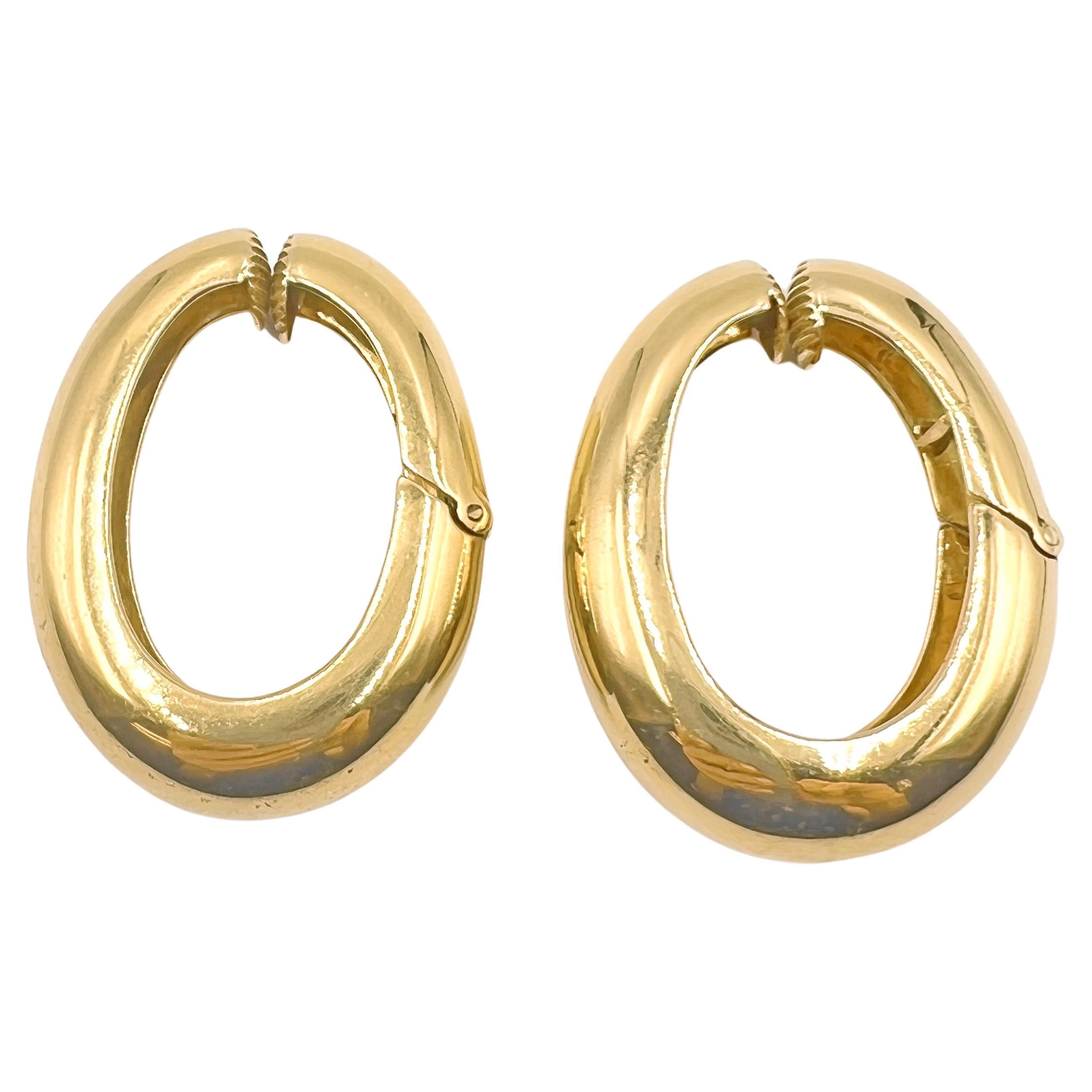 David Webb oval-shaped hoop earrings in polished 18k yellow gold.  Tapered, curved design measuring 1.5