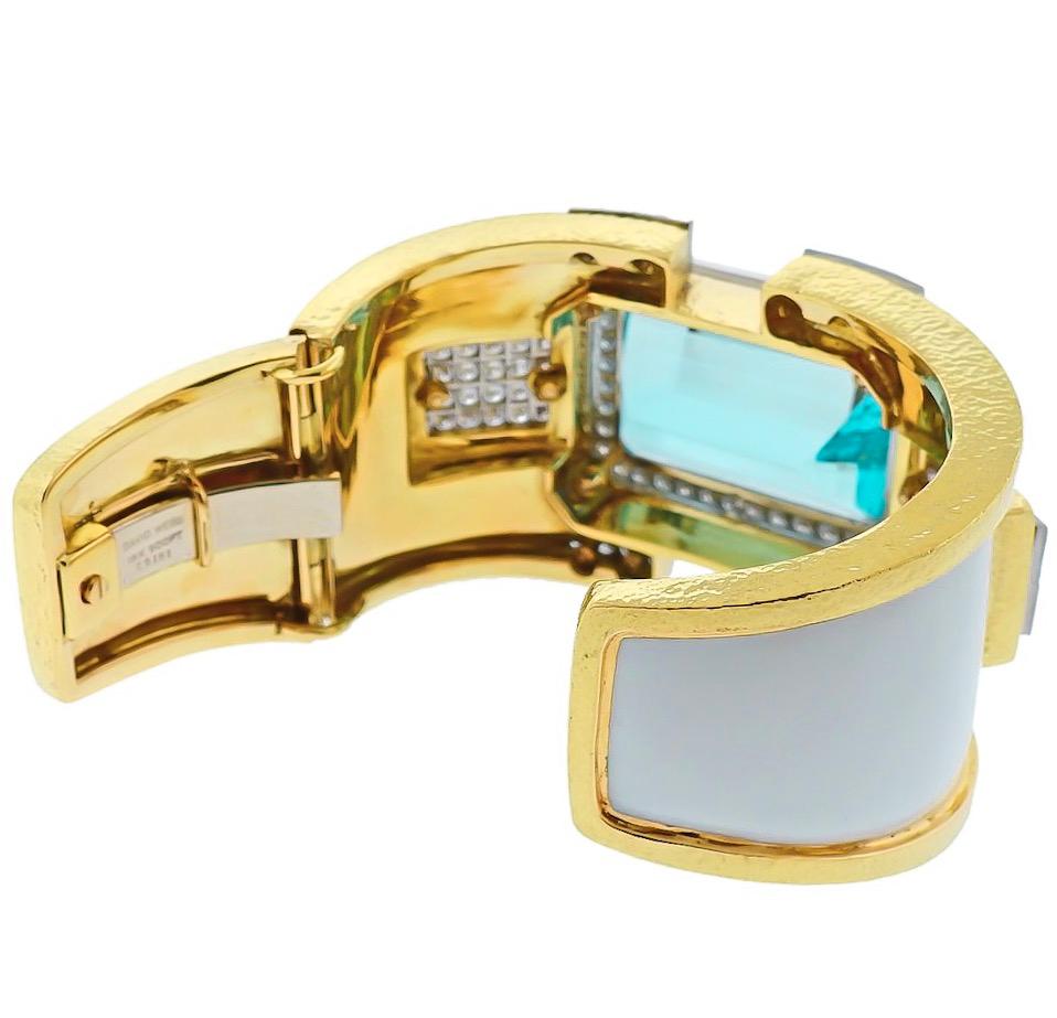 Absolutely stunning large aquamarine and diamond bangle cuff bracelet by David Webb. 

Crafted in 18K Yellow gold and platinum this bracelet features a 90-carat aquamarine, enclosed in a diamond pave set halo. 

Applied with white enamel, secured by