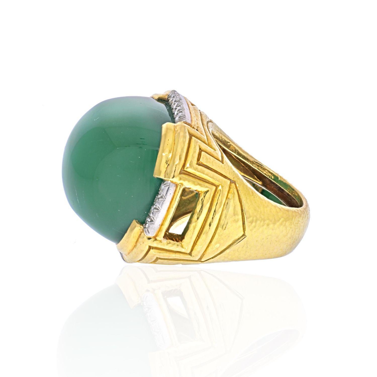 Large Green Chalcedony and Diamond Ring by David Webb.
It is crafted out of solid 18K Yellow Gold with Platinum accents with a hammered finish.
Showcasing one (1) cabochon cut Green Chalcedony, measuring 23.00 x 26.00 mm.
Accenting the ring are