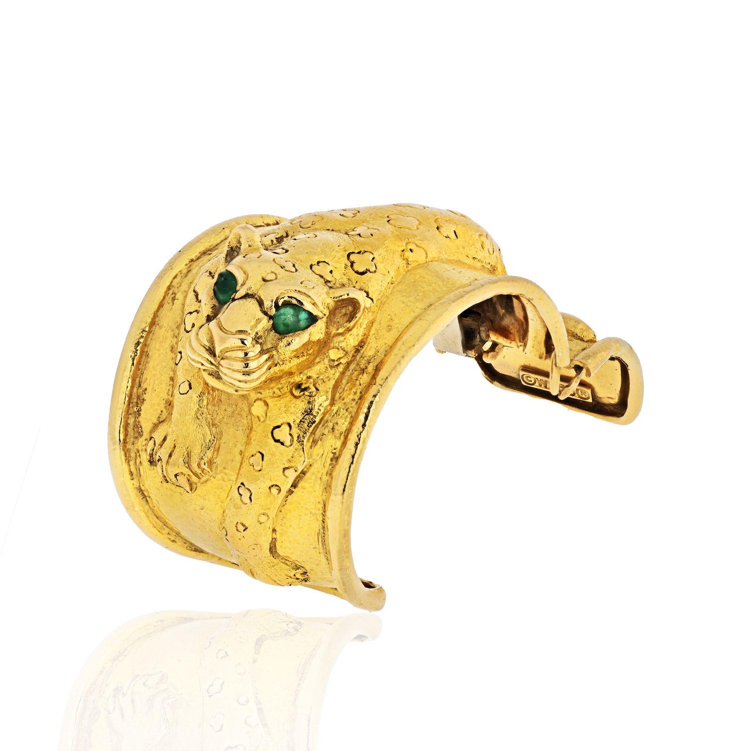 The wide hinged cuff depicting a crouching repoussé leopard set with two pear shaped emerald eyes, the emeralds weighing 0.7 total carats, in textured 18k yellow gold. Handmade in New York City by David Webb.
For a small wrist: 5.75-6 inches
