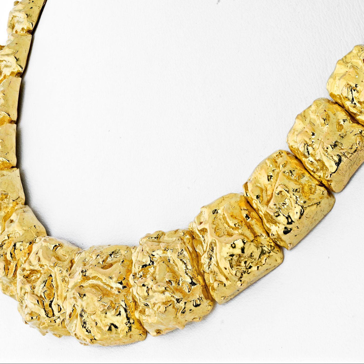 The 18K Yellow Gold David Webb collar necklace is a stunning piece of jewelry that exudes elegance and luxury. Crafted meticulously, it showcases a unique design composed of nugget style hammered gold flat panels that gracefully graduate in size.