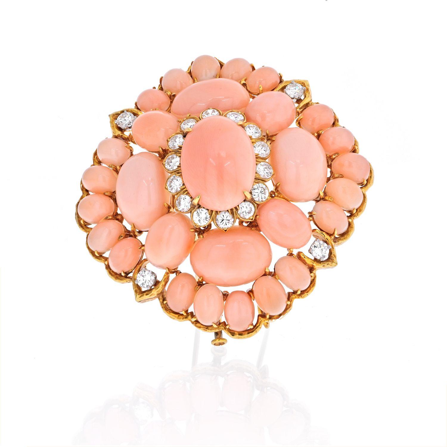 We are absolutely in love with this lozenge-shaped panel pink coral cluster brooch by David Webb. It is composed of cabochon shaped corals and further accented with round brilliant cut accents. The sizable oval cabochon coral is framed three times