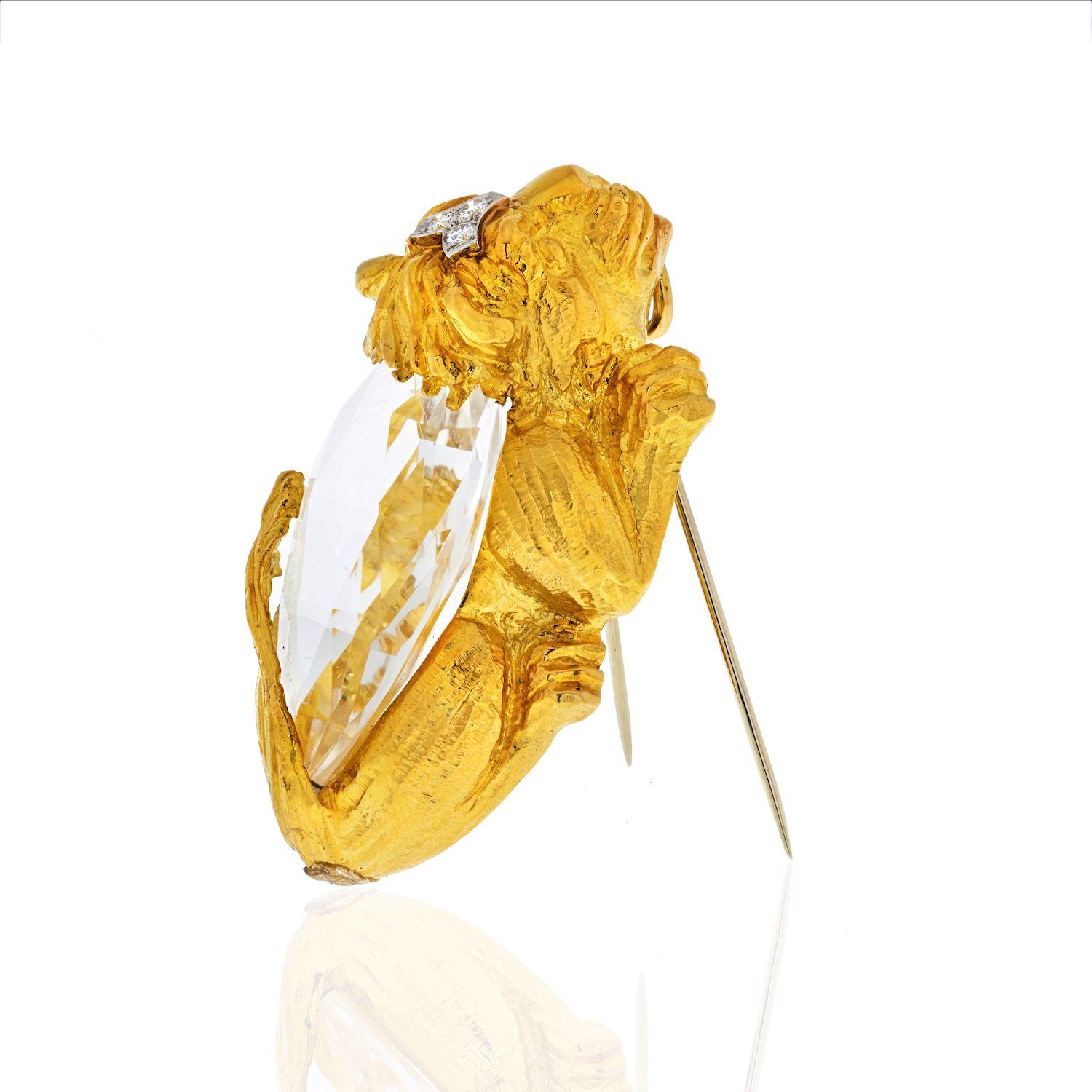 Réalisée en or jaune/platine 18 carats, cette broche/pendentif David Webb a la forme d'un lion accroupi, le corps monté d'un cristal de roche en forme de poire et accentué sur la tête de diamants ronds de taille brillant pesant environ 0,15 carats