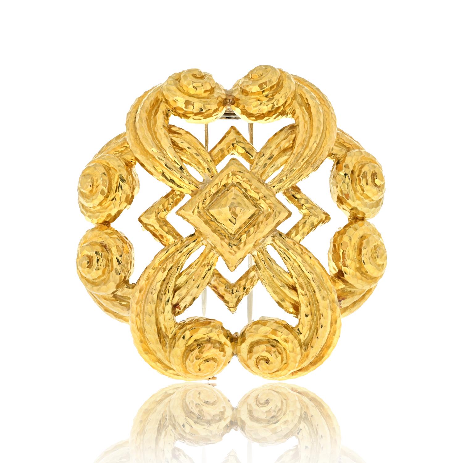 Adorn yourself with timeless elegance through the David Webb 18K Yellow Gold Scrolled Hammered Brooch. 

Measuring 2.5 inches wide, this exquisite piece showcases the meticulous craftsmanship of David Webb. 

The scrolled and hammered design,