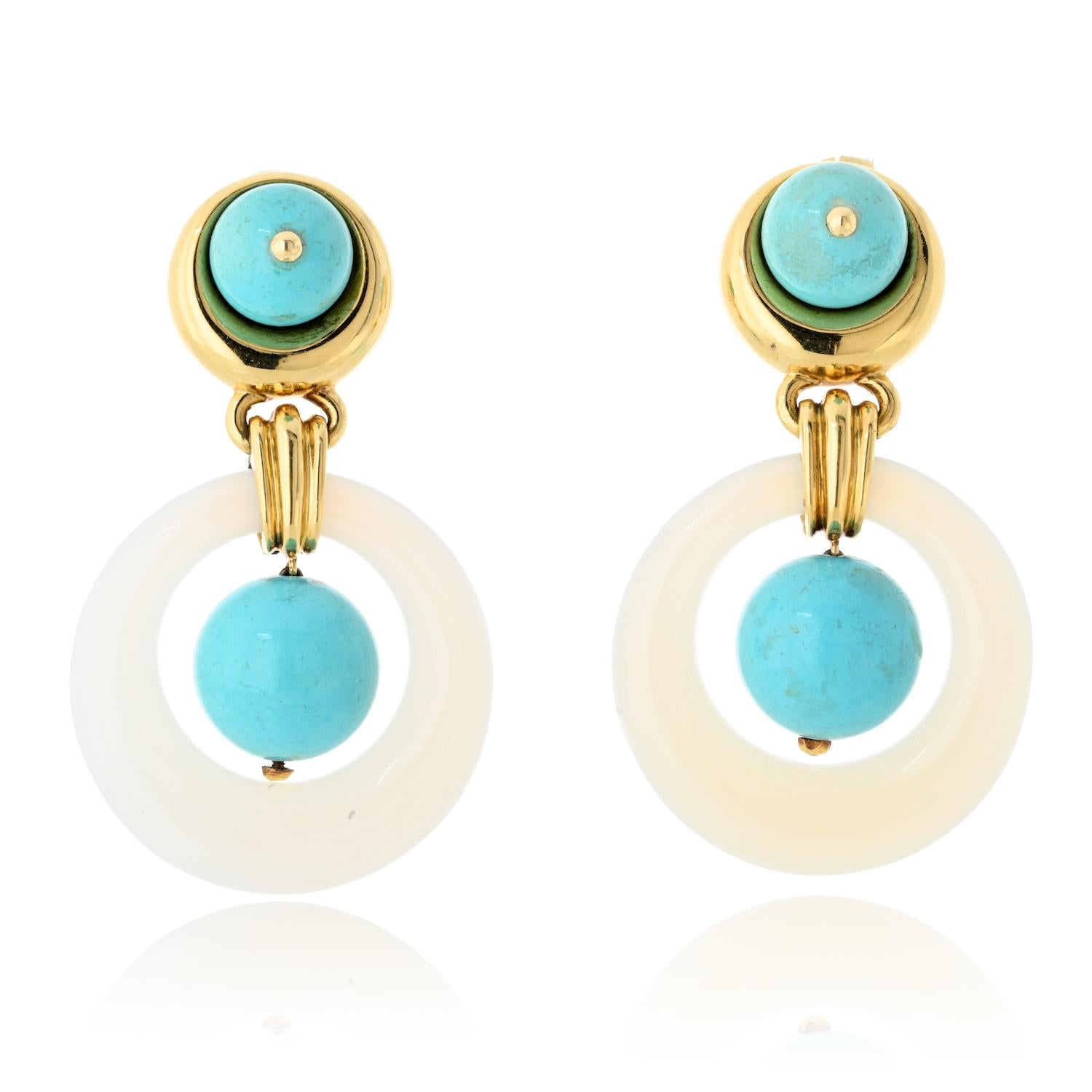 These striking David Webb door knocker earrings seamlessly blend bold design with timeless elegance. Expertly crafted in 18K yellow gold, they showcase vibrant turquoise cabochons bezel-set at the top, framed by polished gold for a sleek contrast.