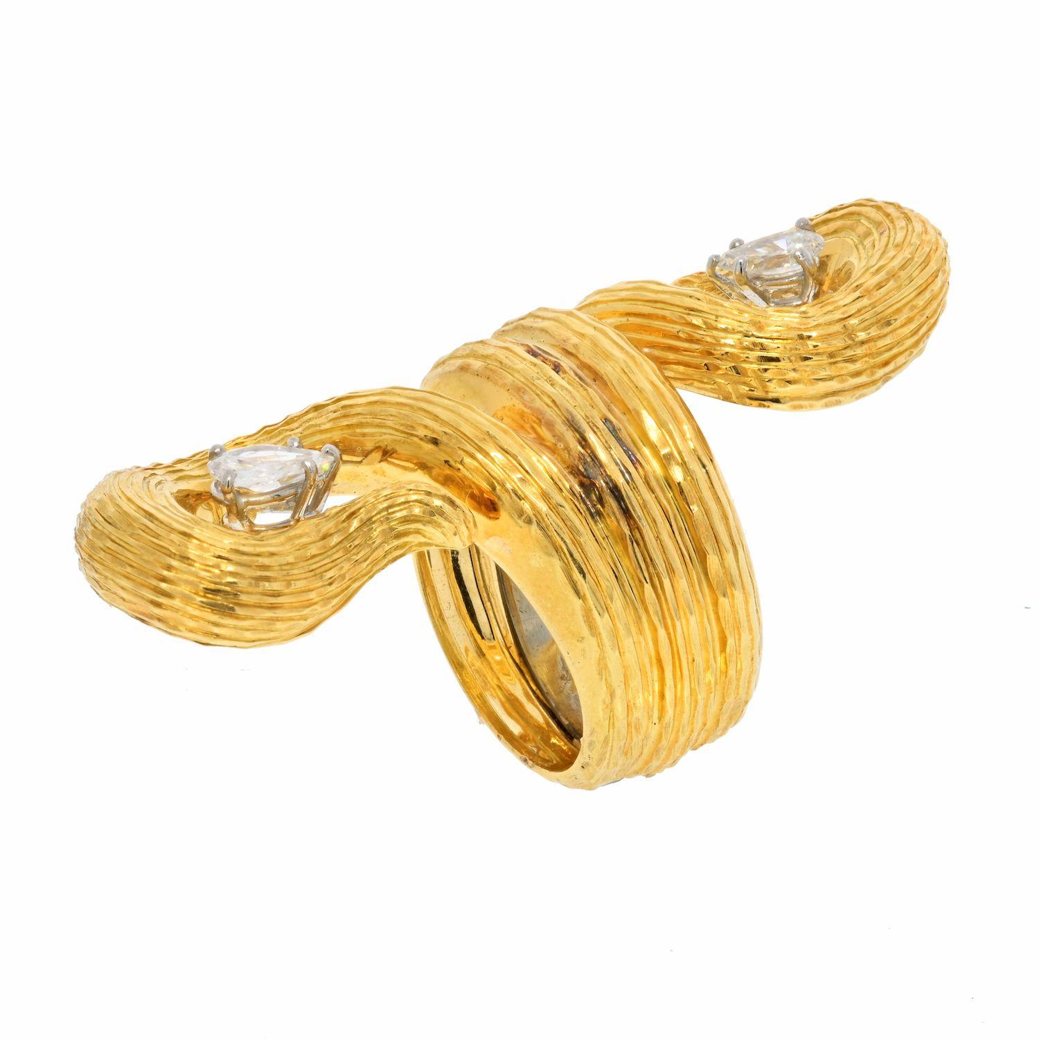 This extravagant designer David Webb diamond cocktail ring is crafted in 18-karat yellow gold weighing 22 grams and measuring 30mm long. Showcasing a bypass design set with a pair of centered, prong set, pear-cut diamonds. Both weighing