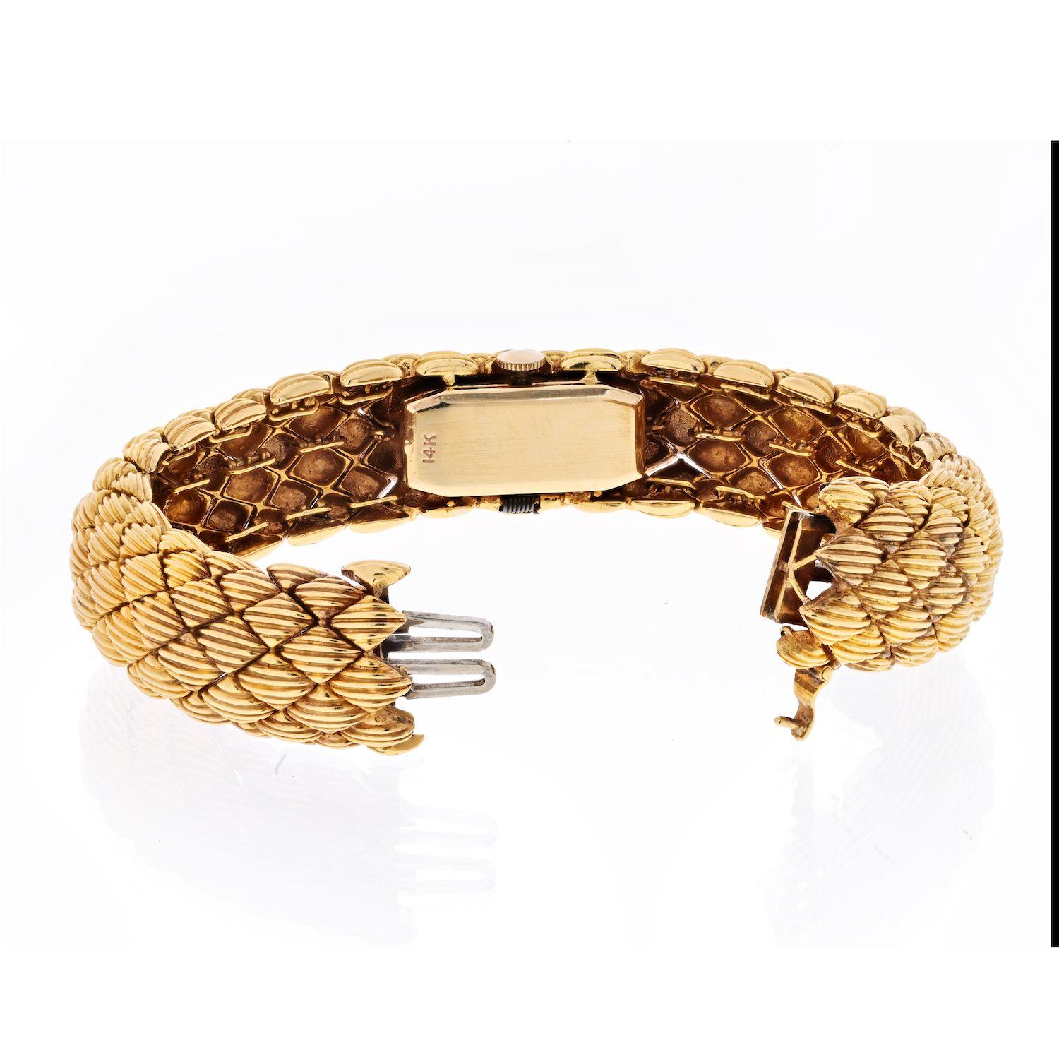Incredible David Webb woven bracelet with a hidden watch.
This stunning piece is comprised of 18kt yellow gold with the watch components being made from 14kt. The bracelet is composed of finely ribbed diamond-shaped links, which conceals the watch