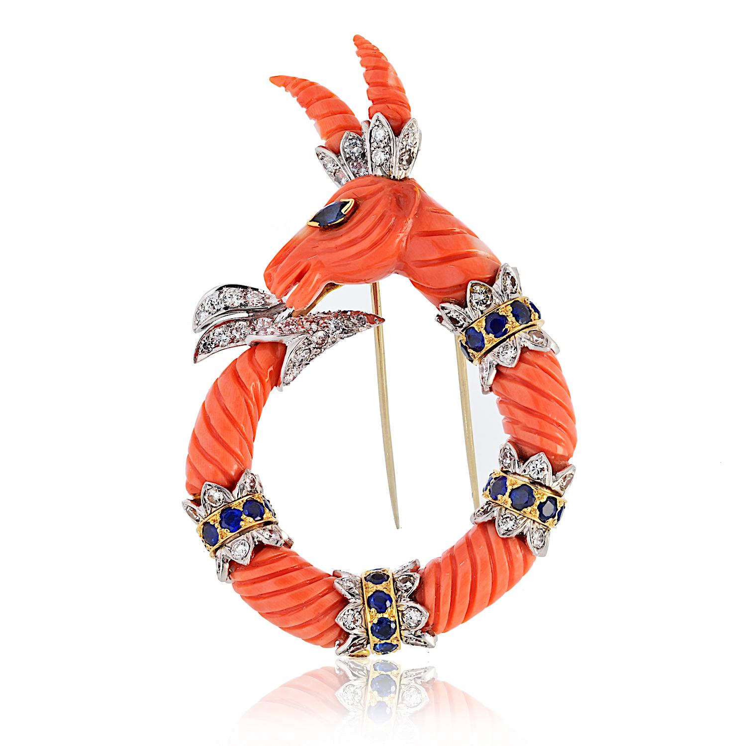This vintage David Webb 18K yellow gold Capricorn brooch is a beautifully crafted piece featuring a charming carved coral mountain goat. 

The intricate detailing brings the Capricorn to life, with a smiling expression and an emerald-set eye. The