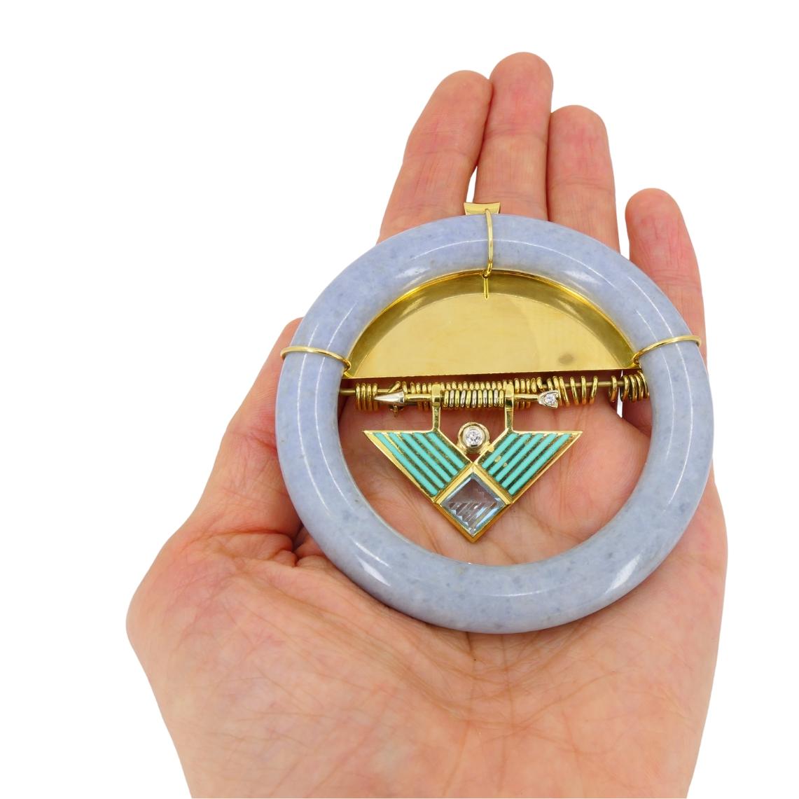 A striking example of mid-century design, this vintage David Webb brooch pendant from the 1960s highlights the designer’s bold approach to geometry and color. The piece centers around a circular jade frame in a soft lavender tone, contrasted with a
