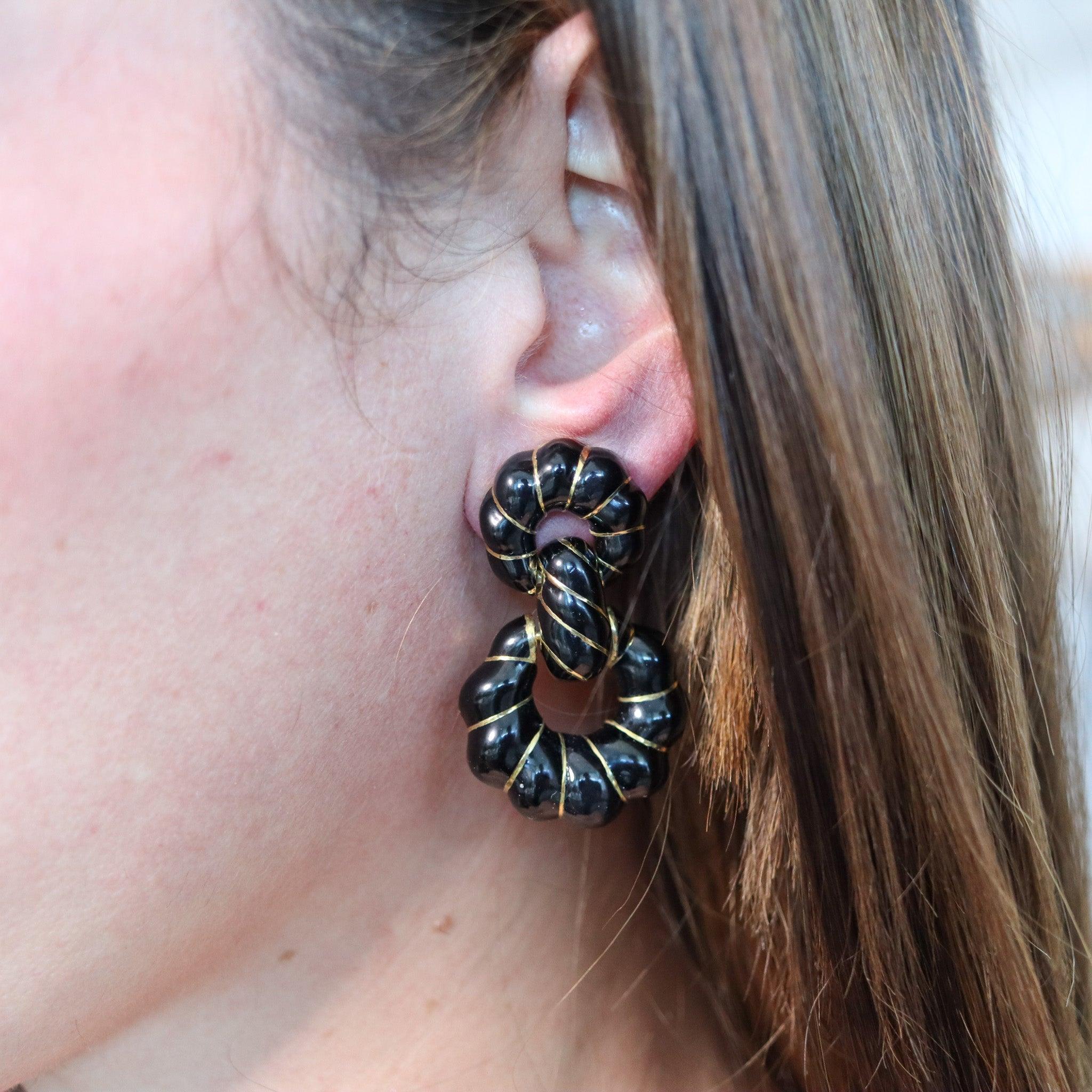 Door knocker earrings designed by David Webb (1925-1975).

This is a beautiful pair of doorknockers earrings, created in New York City at the jewelry atelier of David Webb, back in 1970. These doorknockers dangle earrings have been crafted in solid