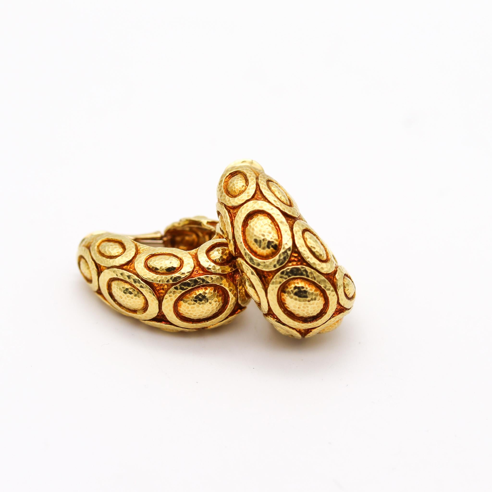 Clips-on earrings designed by David Webb (1925-1975).

Exceptional and magnificent pair of hoop clips earrings, created in New York city at the jewelry atelier of David Webb, back in the 1976. Designed with oval patterned chased gold and described
