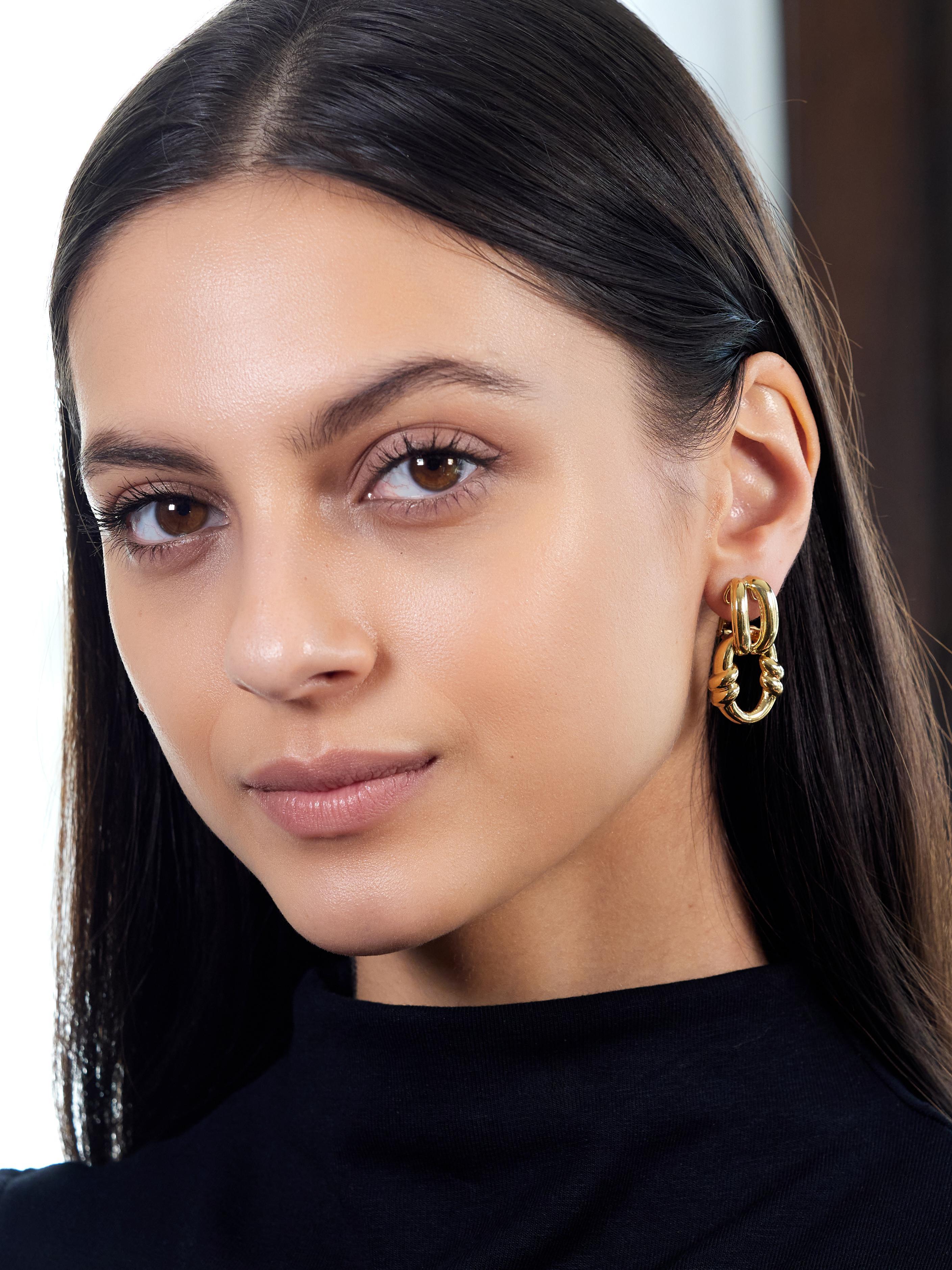 Designed as door knocker style earrings with looped surmount and disk drop
Puffed yellow gold with split open surmount and wrap motif on drop
Featuring a high polish finish
Completed by hinged omega backs
Stamped for 18 karat gold
Signed for David
