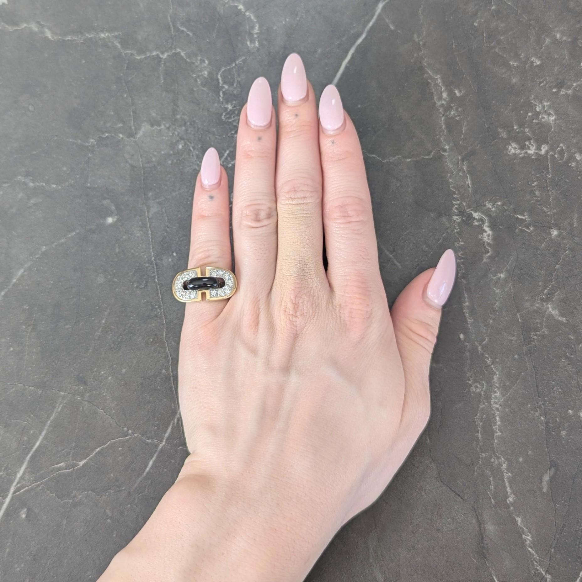 Designed as a pierced buckle motif featuring round brilliant cut diamonds bead set in semi-circles
Weighing approximately 0.84 carat total - G/H color with VS2 clarity
Accented by a raised midsection glossed with opaque black enamel
Completed by