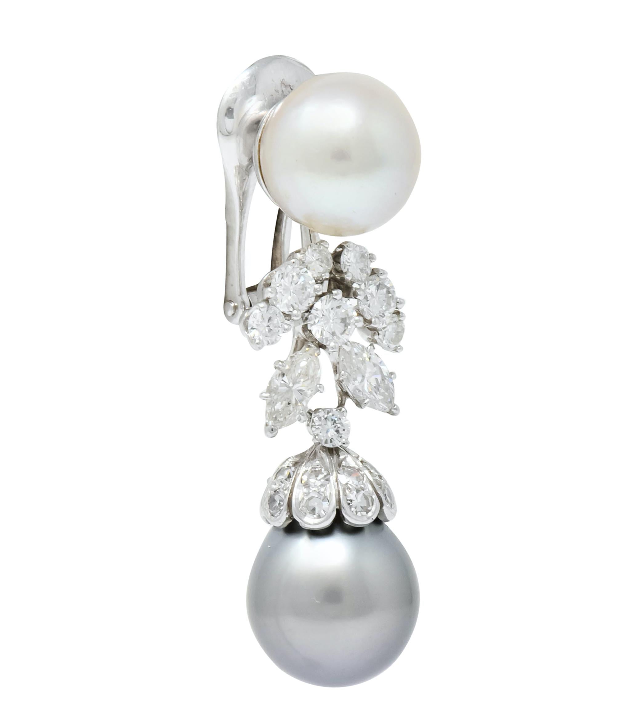 Centering a round cultured pearl surmount measuring approximately 10.3 mm, cream in body color with rosé overtones and excellent luster

With articulated drop featuring foliate motif and scalloped pearl cap set throughout with round brilliant cut,