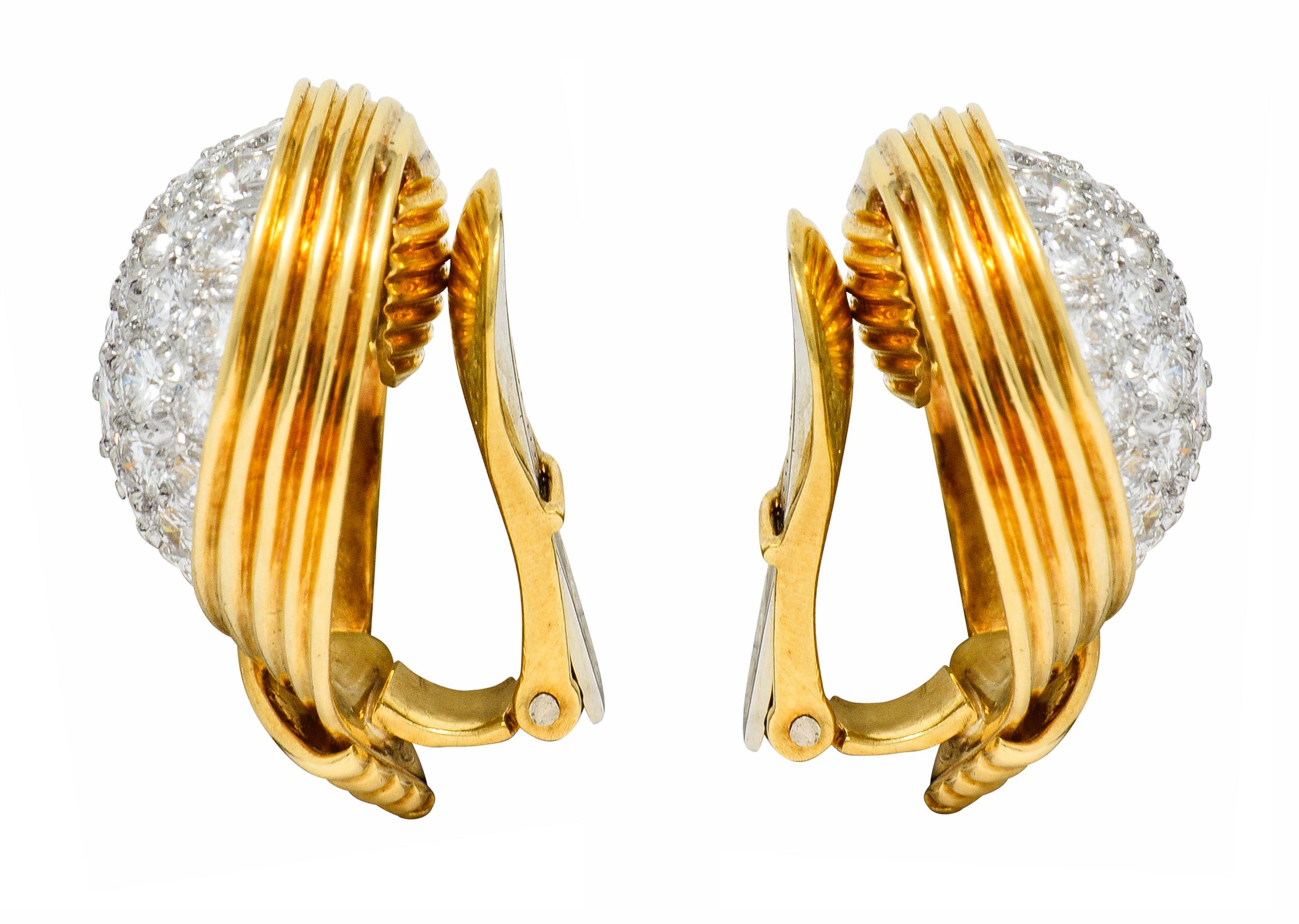 Ear-clip earrings center a platinum pavè field of round brilliant cut diamonds

Weighing in total approximately 3.50 carats with G to I color with VS clarity

With a deeply ridged polished gold surround

Completed by hinged omega backs

Signed Webb