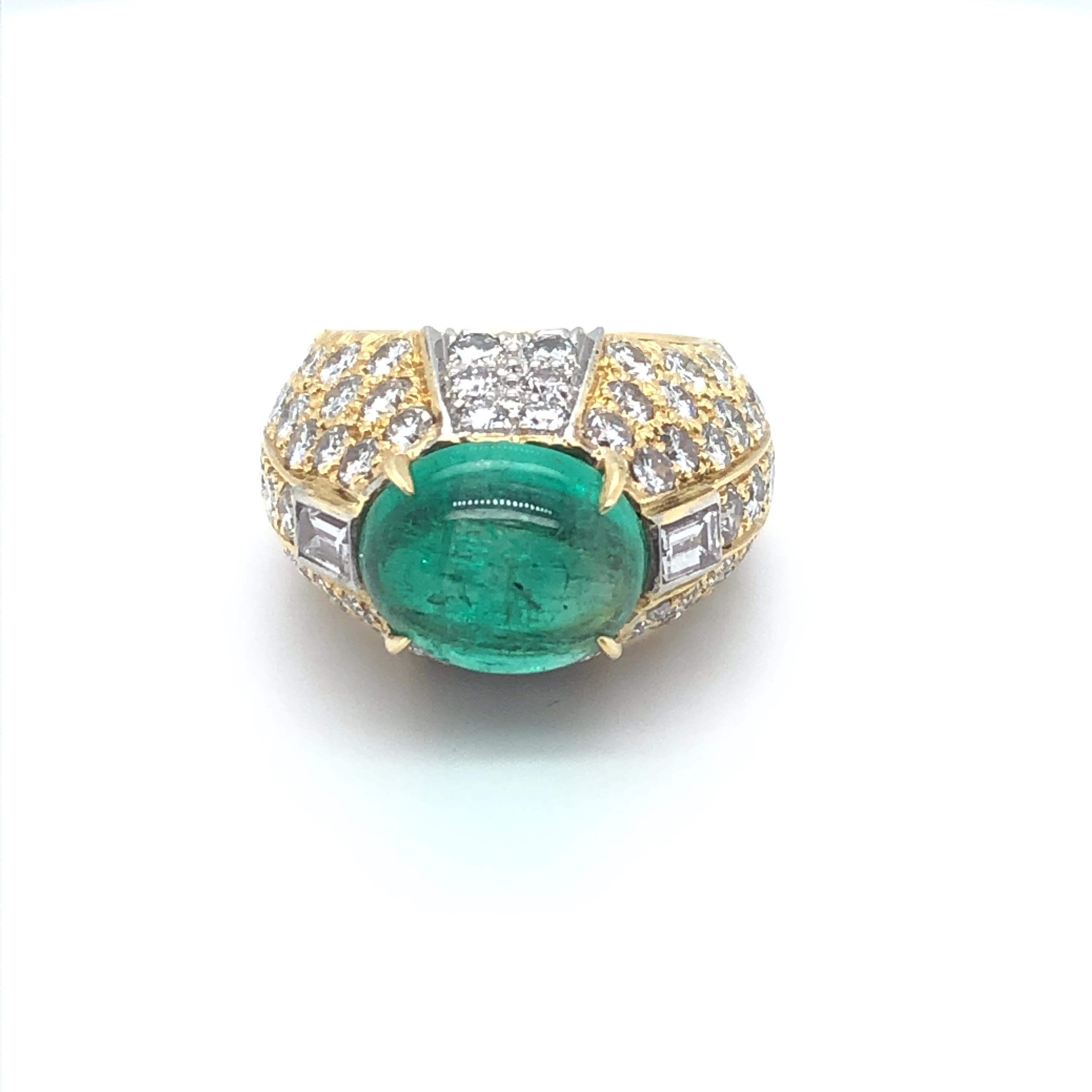 This David Webb ring features an approximately 4.5ct cabochon emerald, accentuated by an estimated 4.5cts of round brilliant (and two emerald cut) diamonds set in alternating panels of 18k yellow gold and platinum.  The external edges of the yellow