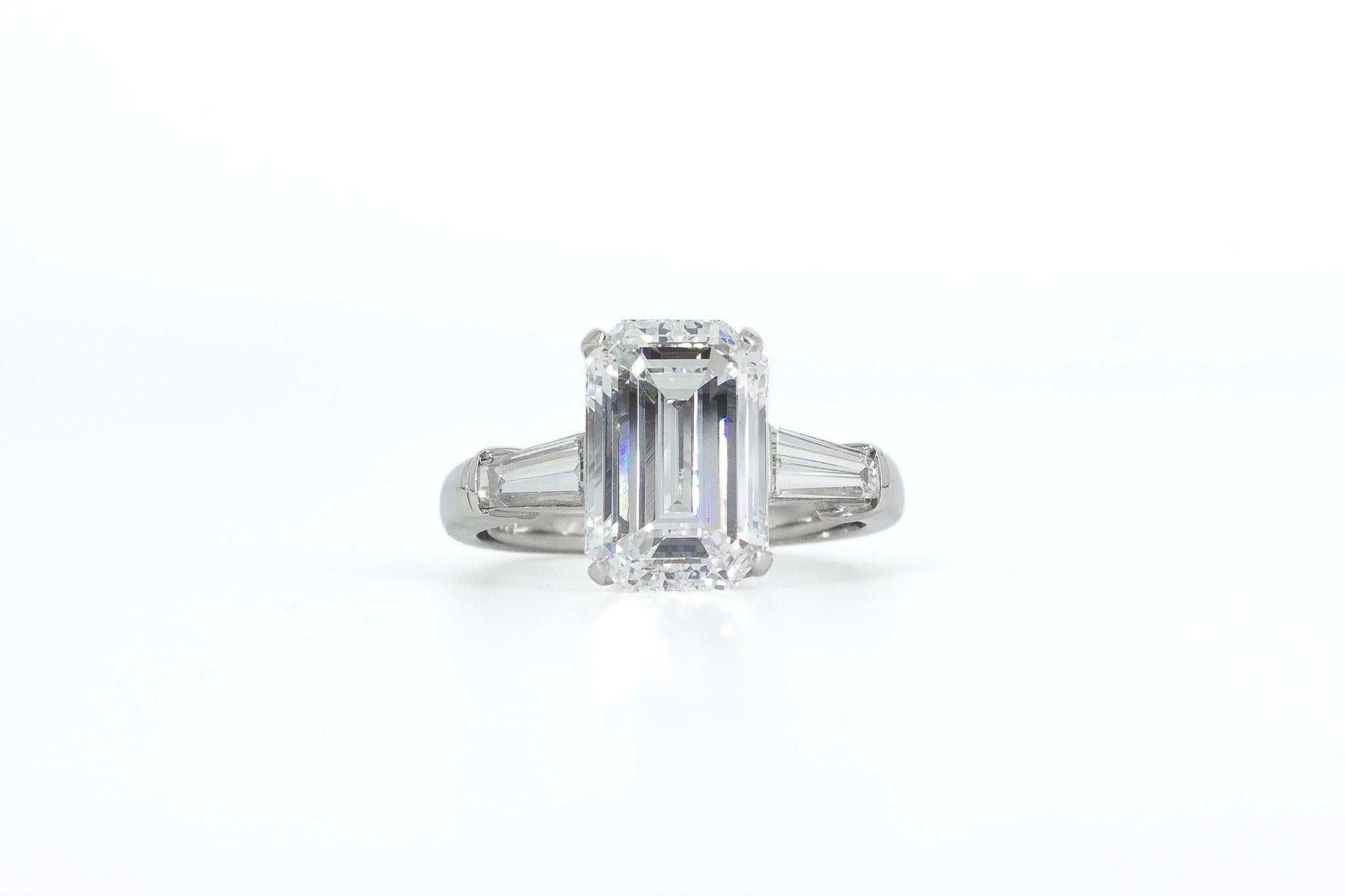 J. Birnbach è orgogliosa di presentare questo anello firmato David Webb in platino con tre pietre, caratterizzato da un'incredibile  diamante centrale da 5,01 carati con taglio smeraldo. Incastonato in una lussuosa montatura in platino, questo