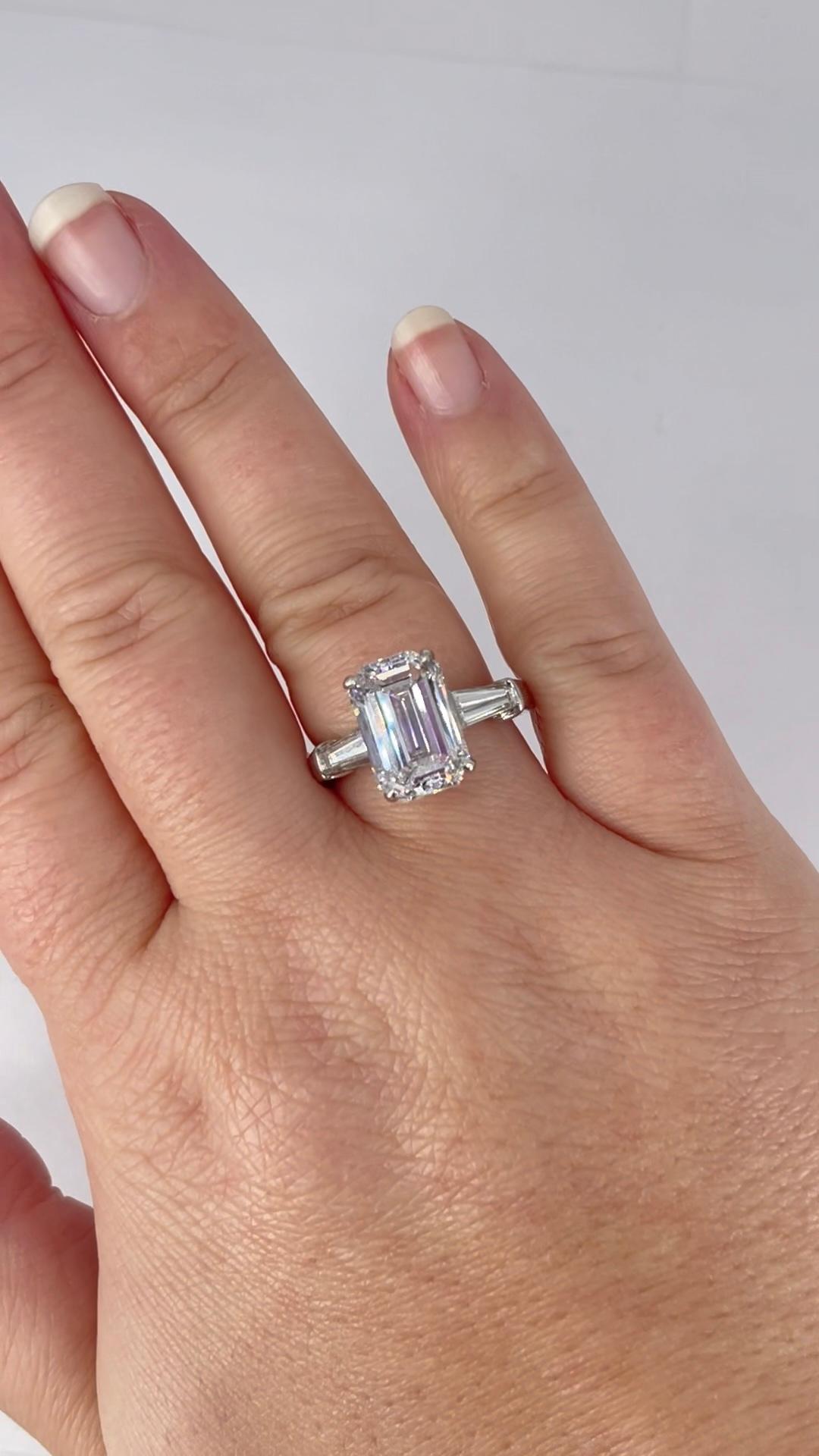 This elegant engagement ring by David Webb is a stunning example of timeless quality and craftsmanship. The ring showcases a 5.01 carat emerald cut diamond, certified by GIA as F color and VS1 clarity. The F color grade is colorless, and VS1 clarity