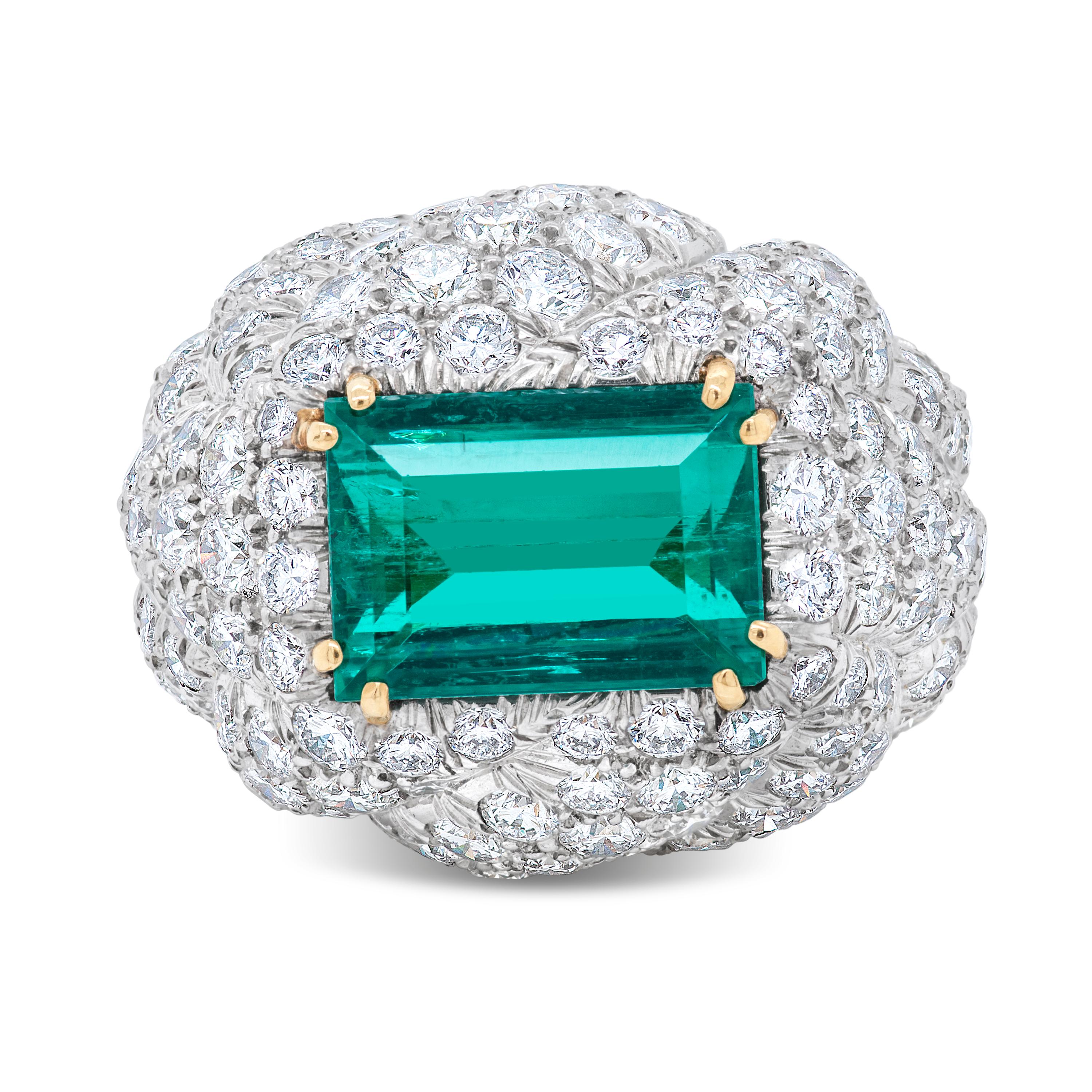 This David Webb ring features a 7.20 carat emerald cut Colombian emerald accompanied by an AGL report.  The emerald is surrounded by 160 round brilliant cut diamonds totaling approximately 7.33 carat with F color and VS clarity, pave set in