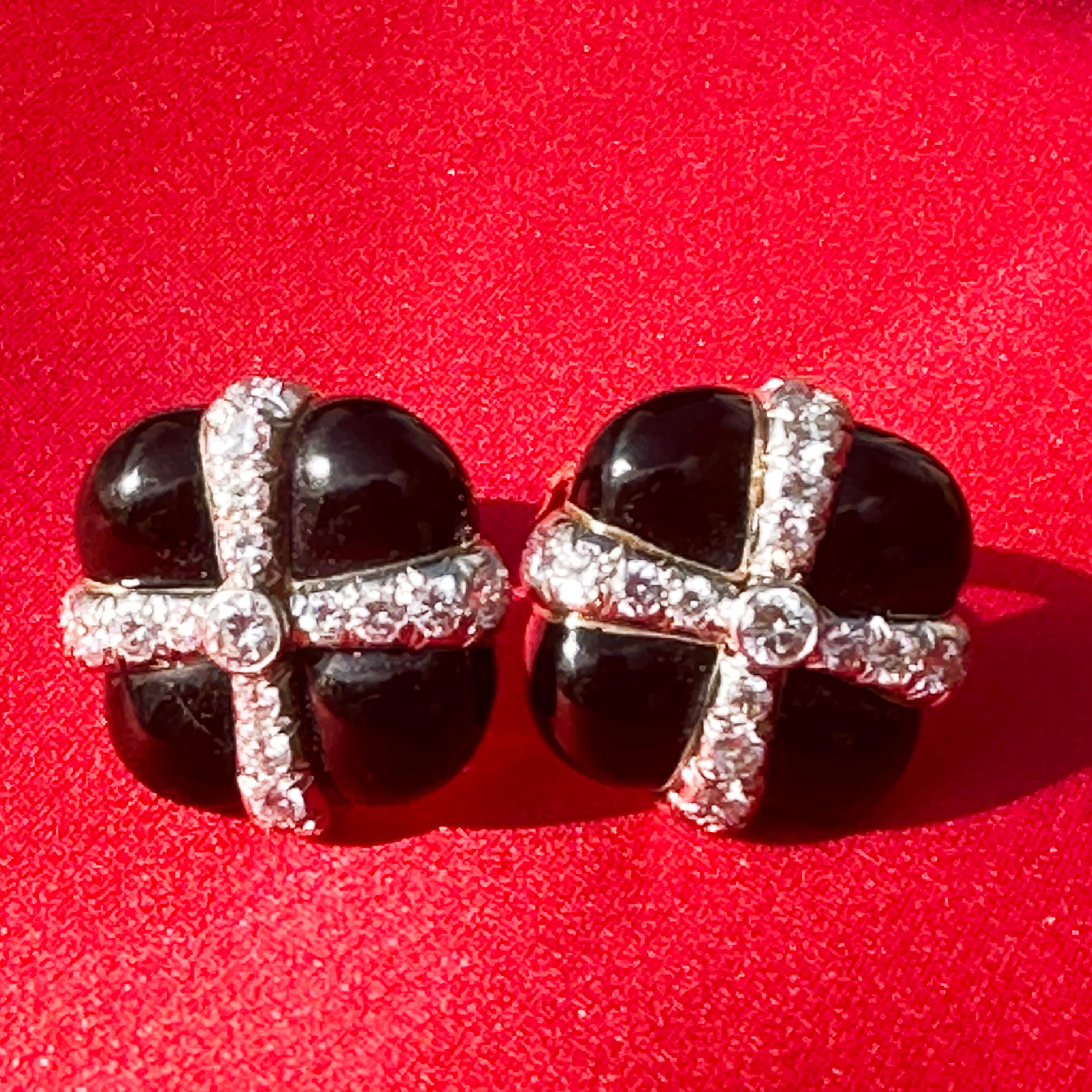 Slightly bombe in form, these fun glossy black enamel squares are wrapped in diamond ribbon. In lieu of a bow, is a bright round diamond weighing approximately ¼ carat.

Diamonds weigh approximately 3.5 total carats
Approximately one inch by one