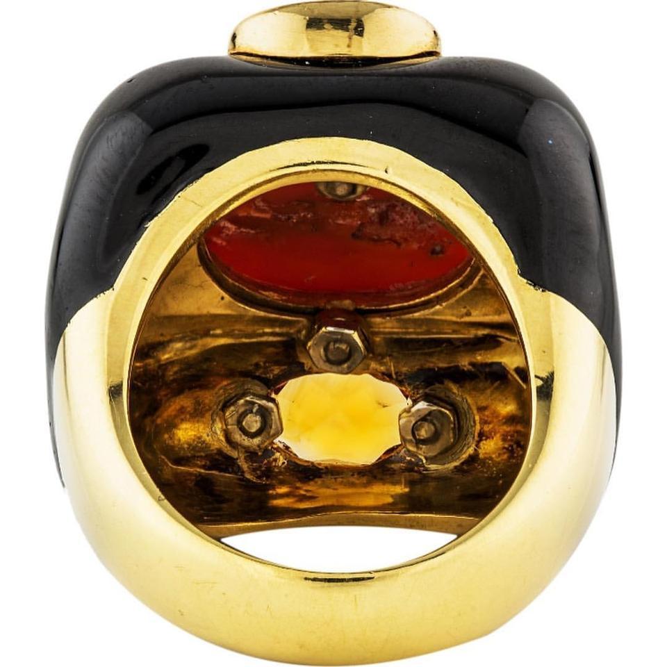 David Webb gold black enamel right hand ring. This ring has signs of wear. Please review pictures or ask for additional angles.

18K Yellow Gold
Enamel
Coral
Citrine