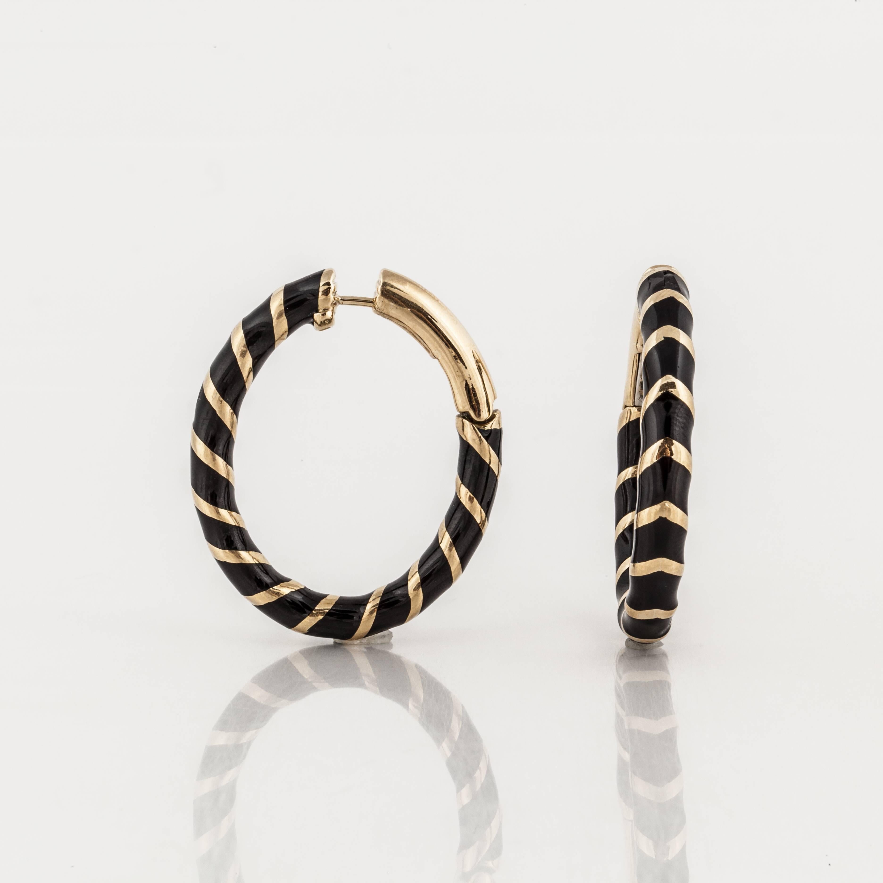 These David Webb earrings are elongated hoops composed of 18K yellow gold with stripes of black enamel.  They measure 1 3/8 inches long by 1 1/4 inches wide.  They are marked 