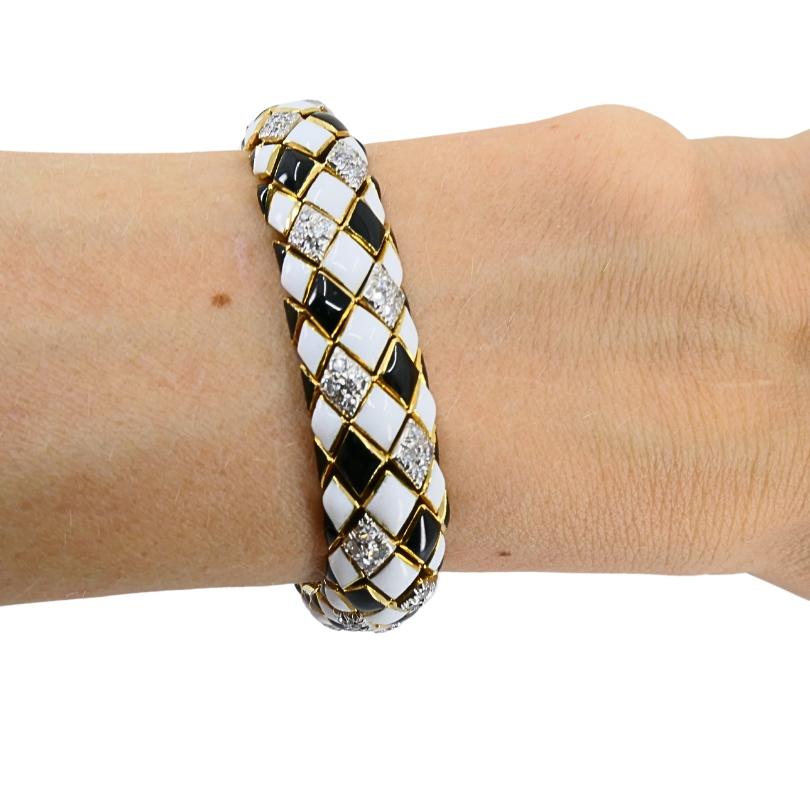 Pulsera vintage David Webb de diseño arlequín, fabricada en oro de 18 quilates, con esmalte y diamantes.
El motivo arlequín alterna azulejos esmaltados en blanco y negro brillante, con cada sección esmaltada enmarcada por una celosía dorada. Los