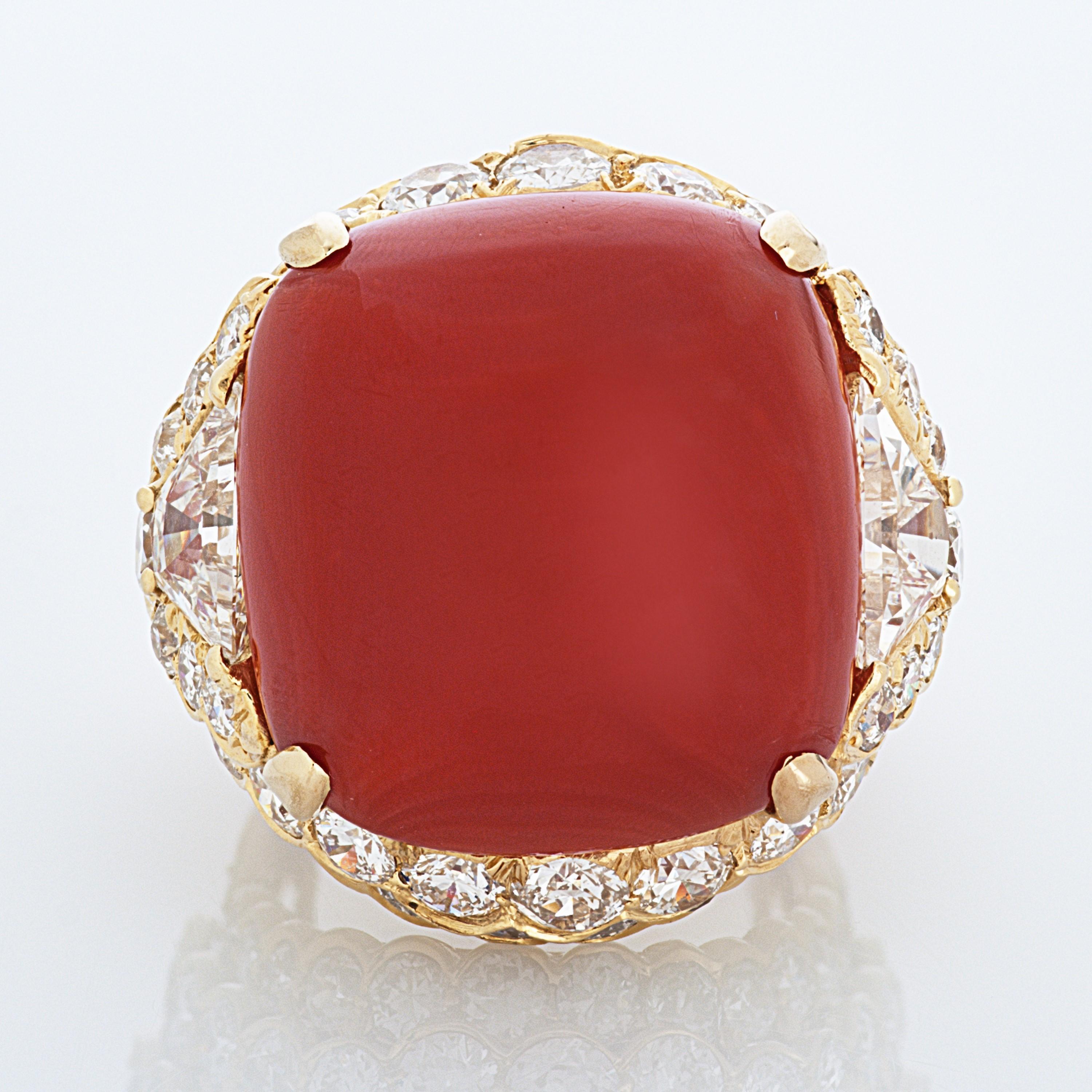 David Webb Cabochon Coral and Diamond Ring in 18 Karat Yellow Gold, accompanied by a David Webb box and David Webb Certificate of Authenticity.

The center stone of this ring is a cabochon coral measuring 20.9mm by 19.6mm, it is accented by a