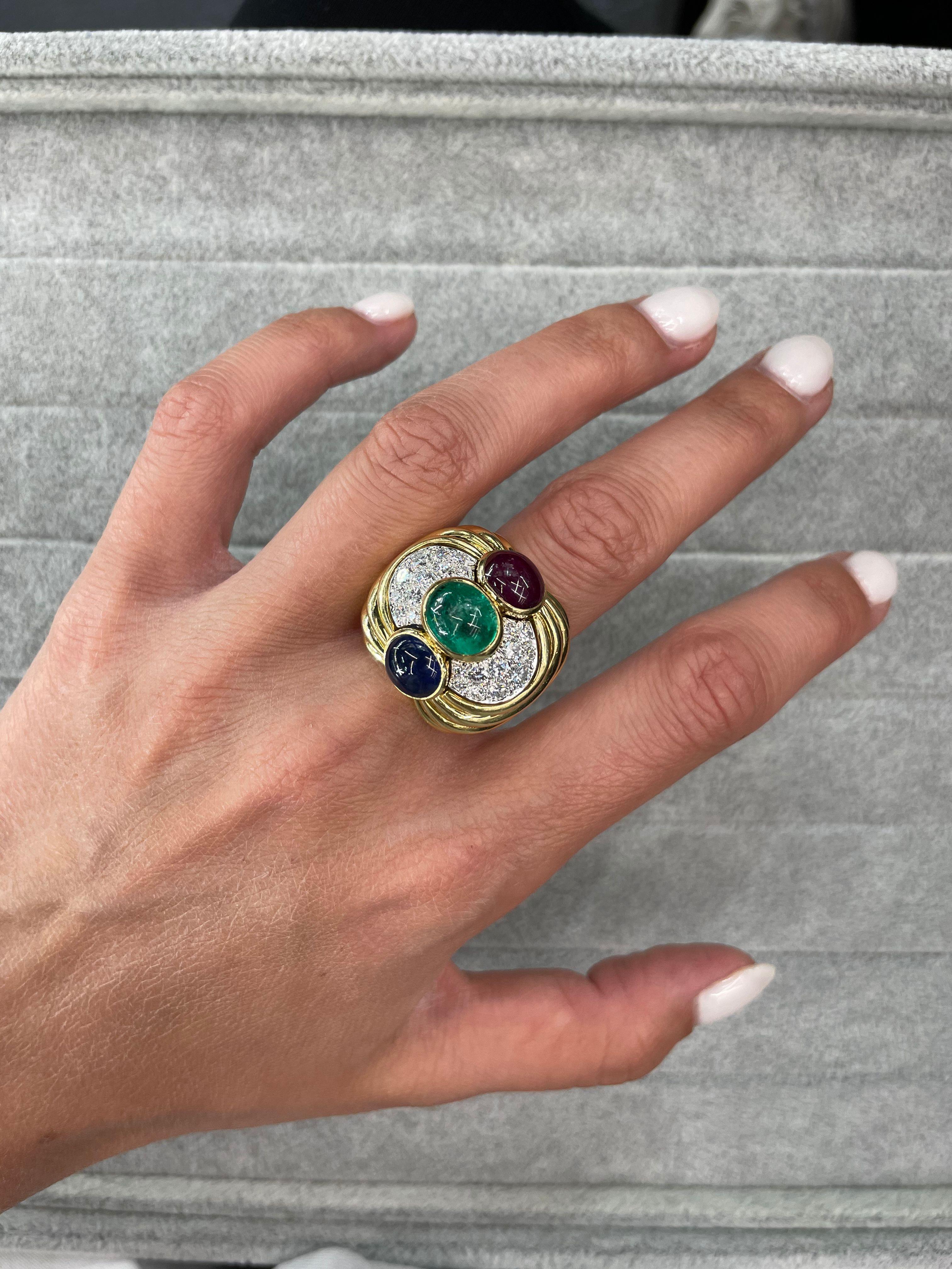Abslutely stunning ring by David Webb comes to us from the 70's but it looks like it could've been manufactured yesterday. 

It is in perfect condition and features three lovely gems: a ruby, an emerald and a sapphire nested one above the other in a