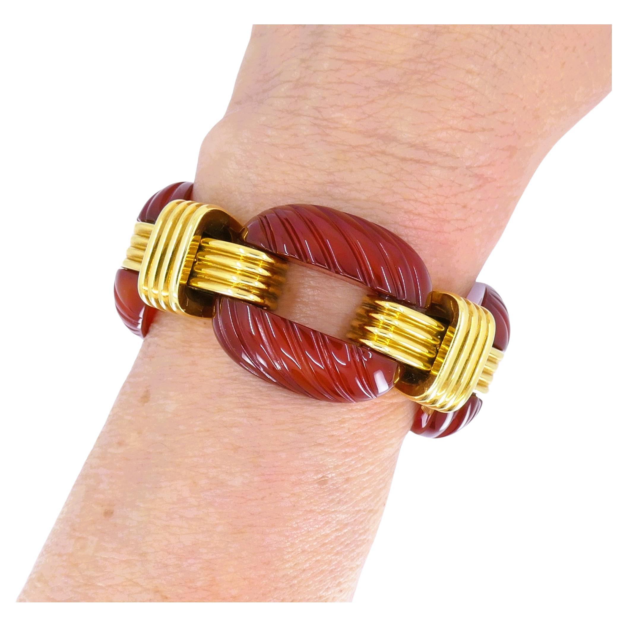An impressive vintage bracelet by David Webb, made of carnelian and 18k yellow gold. 
The bracelet consists of carved carnelian links alternating with cross-shaped gold links. The squares are beautifully textured by using a carving technique. Glossy
