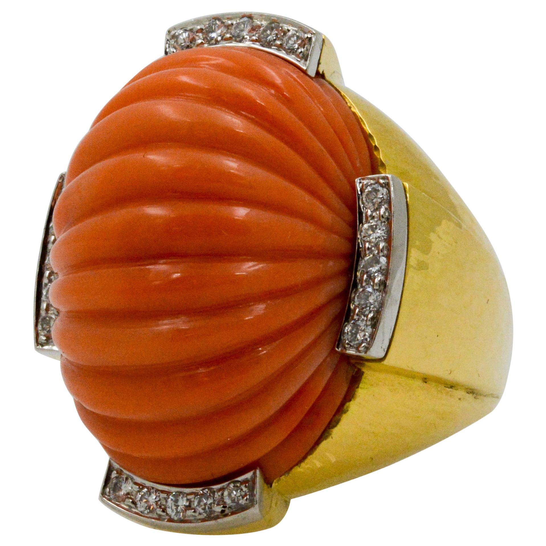 This 18k platinum and yellow gold David Webb carved coral ring is a knock out piece. The coral has a rippled dome design that is surrounded by four sections of diamonds. The round diamond accents feature a total weight of .50 carats. 