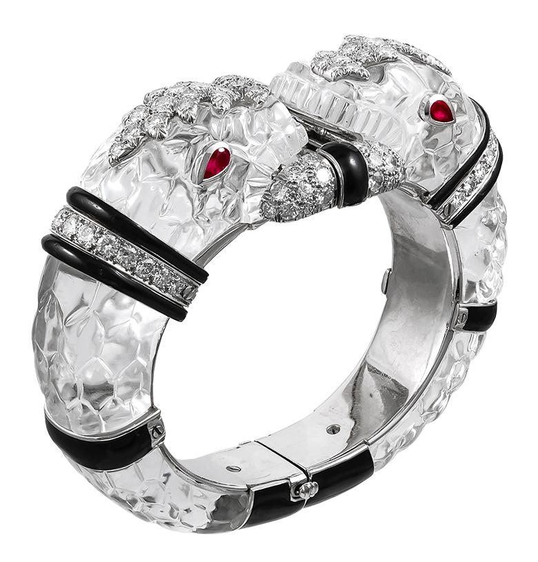 David Webb Carved Crystal Enamel Diamond Chimera Bracelet in Platinum and 18k White Gold.
Exquisitely designed as two opposing carved rock crystal and black enamel chimera heads on an 18k gold and platinum bangle, each head is detailed with