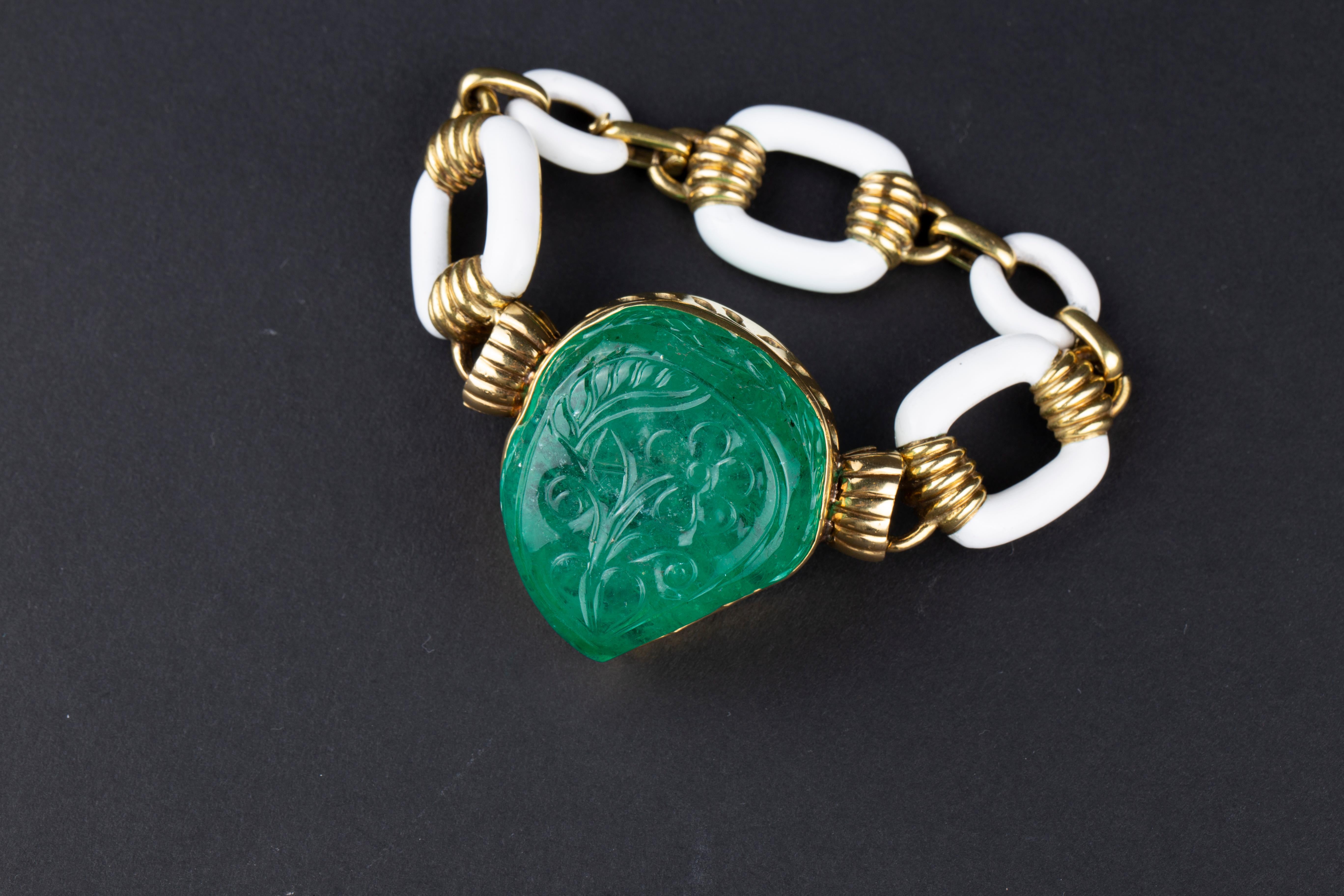 An Impressive David Webb Large Carved Emerald Bracelet (130 carats) mounted on White Enamelled 18k Yellow Gold. Made in the USA, circa 1970