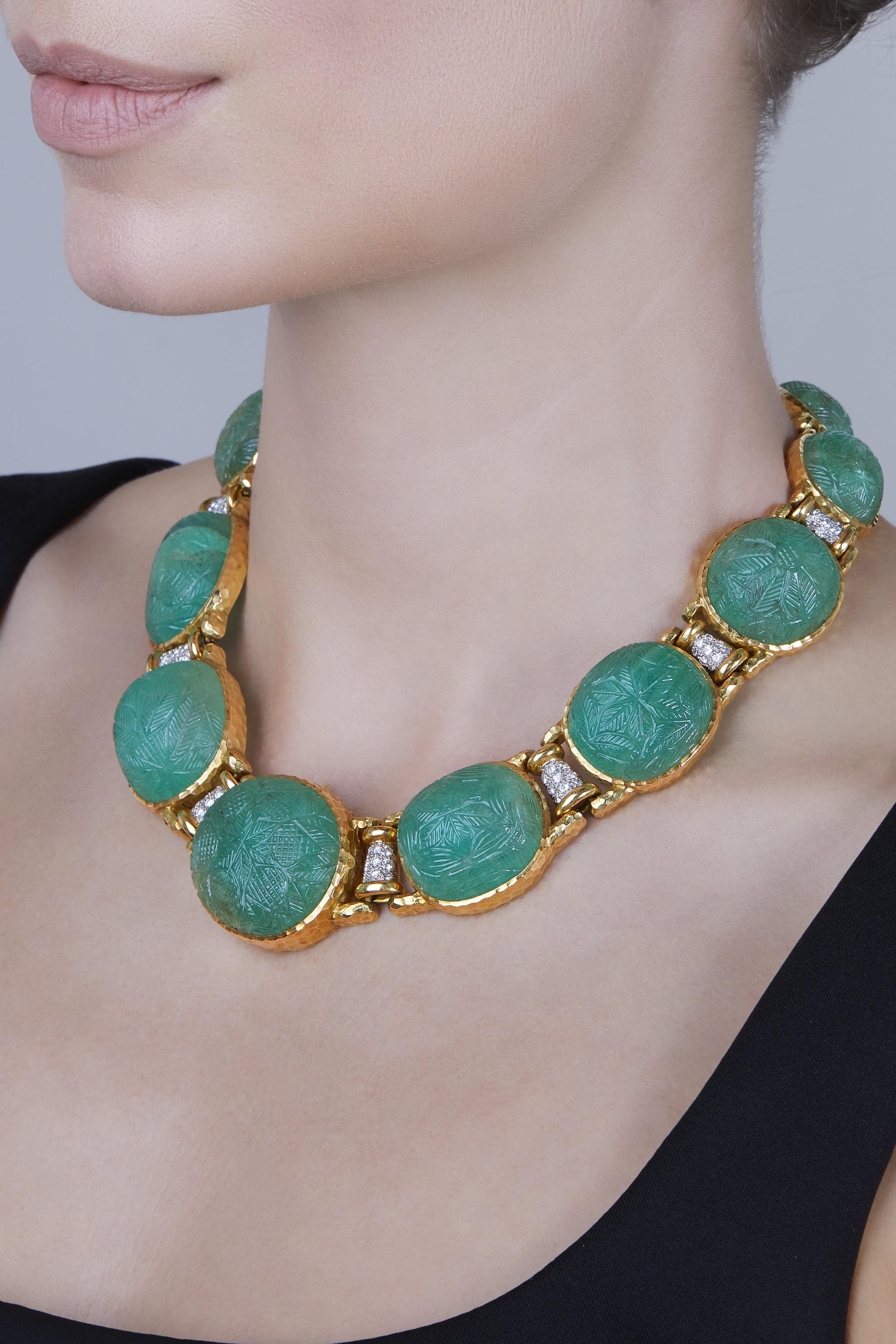 A stunning David Webb necklace composed of 12 carved emerald cabochons bezel-set within hammered gold links, accented by round diamonds. Inner circumference measures 14.5 inches. Made in the USA, circa 1970.