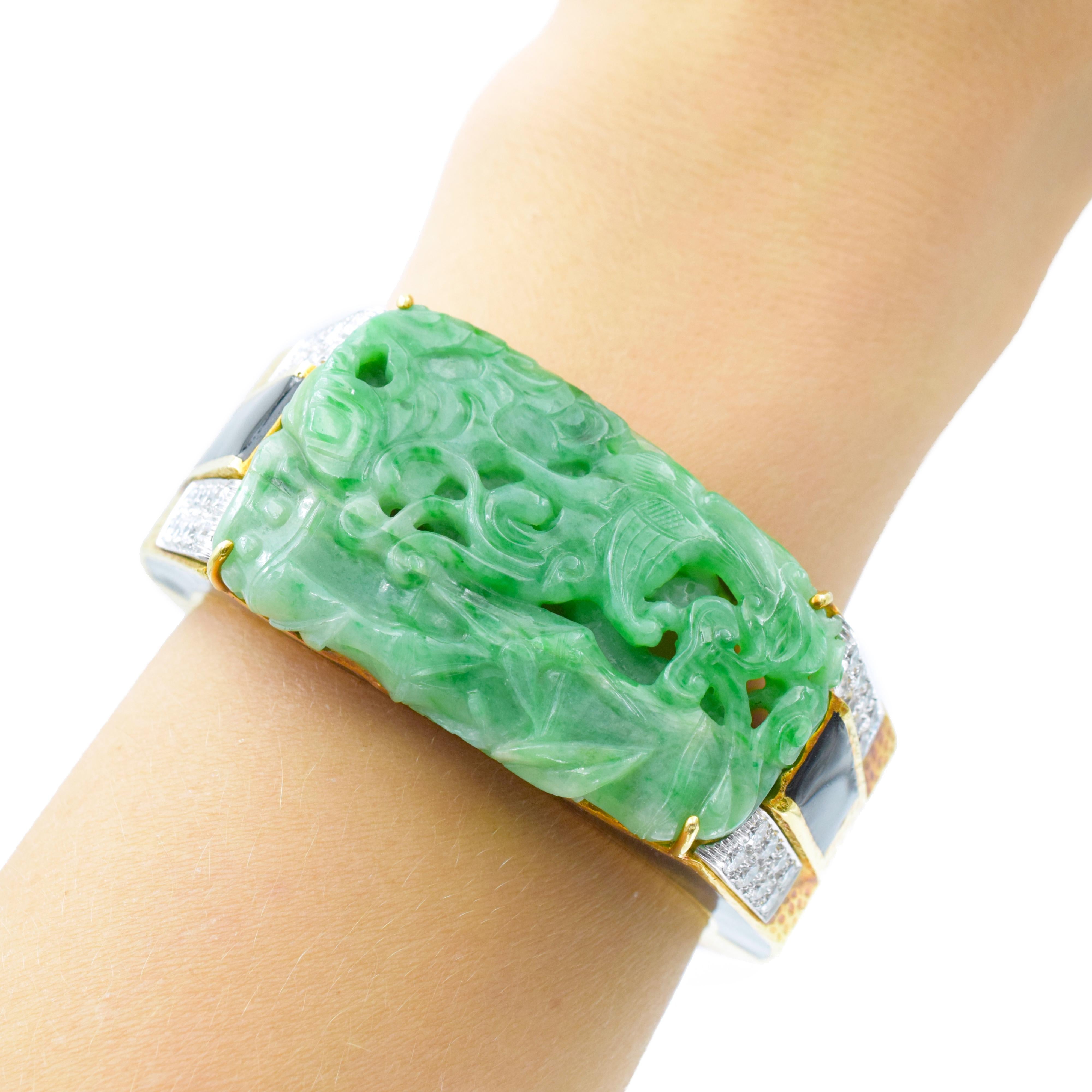 David Webb Carved Jade, Black Enamel and Diamond Cuff Bangle Bracelet In 18k yellow gold and platinum. This tapered hammered gold bangle centering a modified rectangular carved jade panel depicting a phoenix within bamboo measures approximately 52.0
