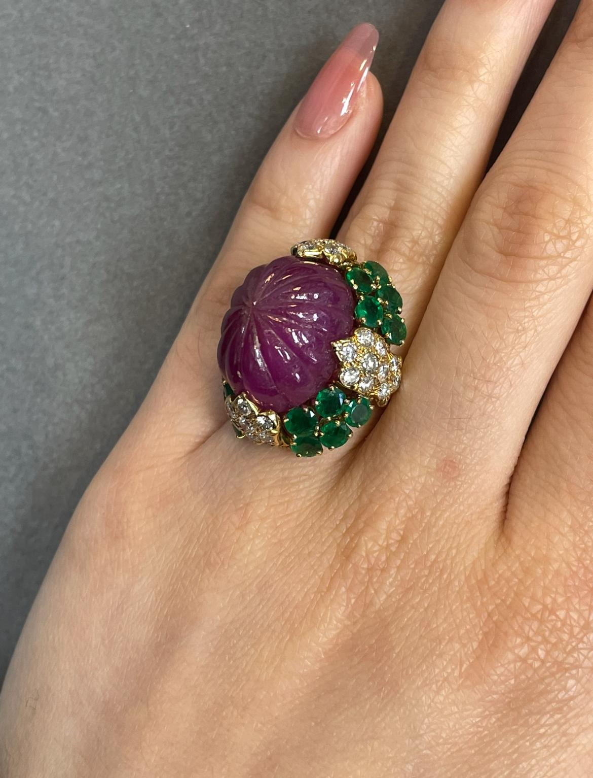 David Webb Carved Ruby, Emerald, and Diamond Ring 

A yellow gold ring by David Webb featuring one carved ruby, 20 round-cut emeralds, and 40 round-cut diamonds.

Accompanied by a copy of the original David Webb invoice dated December 20th 1967
