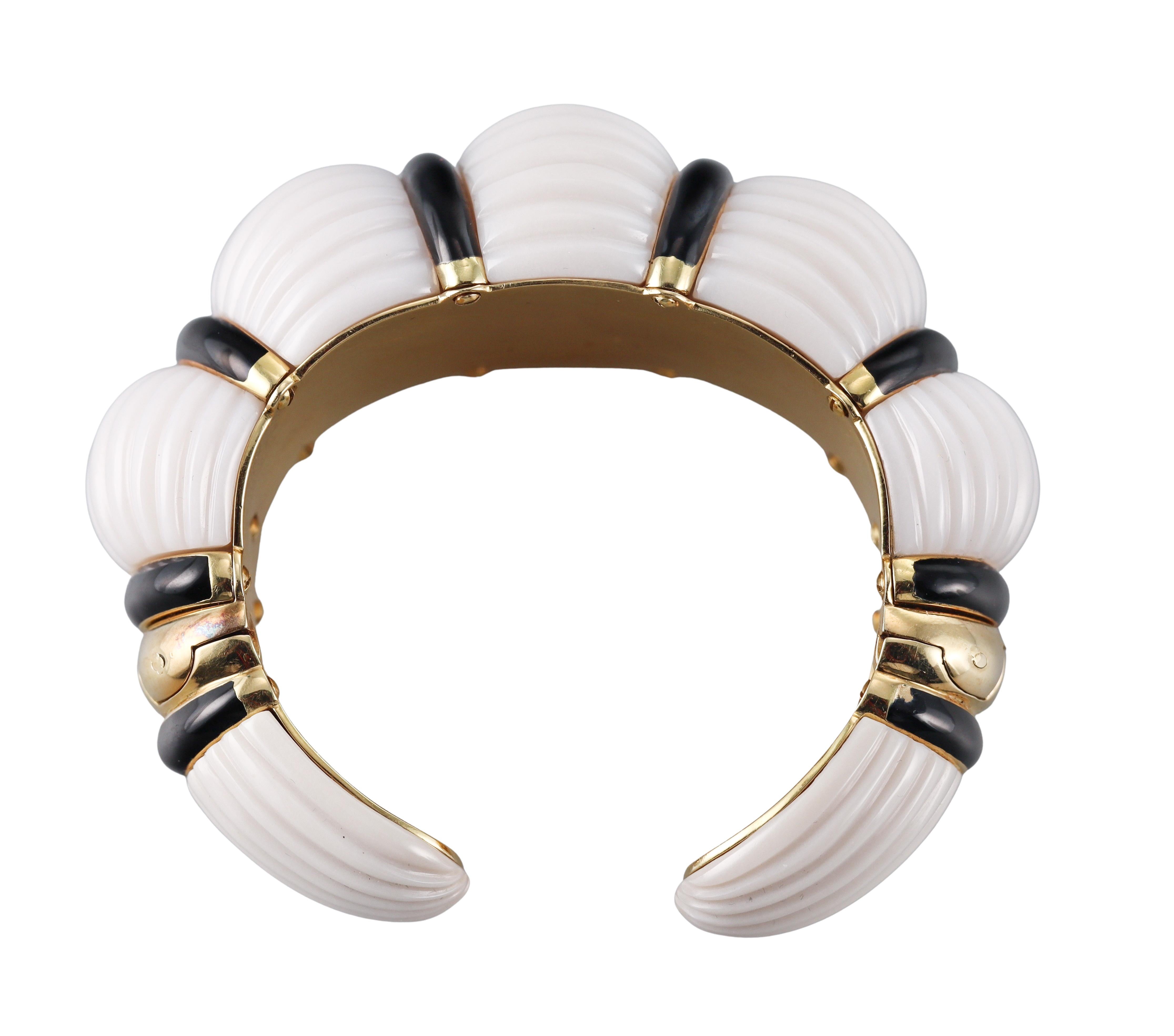 Large 18 yellow gold cuff bracelet by David Webb, featuring carved white and black onyx. Bracelet will comfortably fit approx. 7