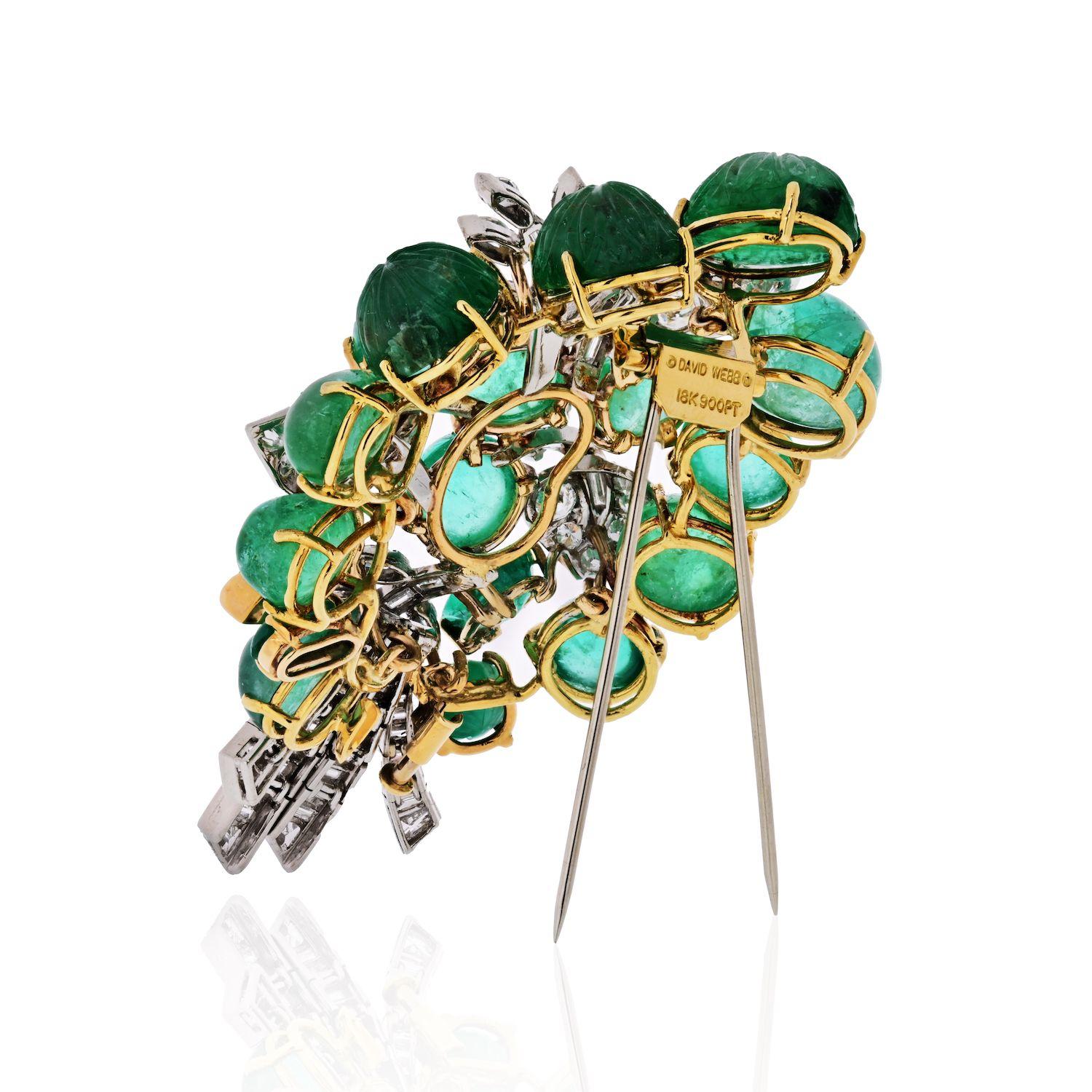 David Webb platinum brooch crafted with carved green emeralds and dimaonds. An impressive dress brooch of approx. 3 inches in length executed in a stylized foliate motif.
Containing close to 20 cabochon emeralds, some carved and some not, round,