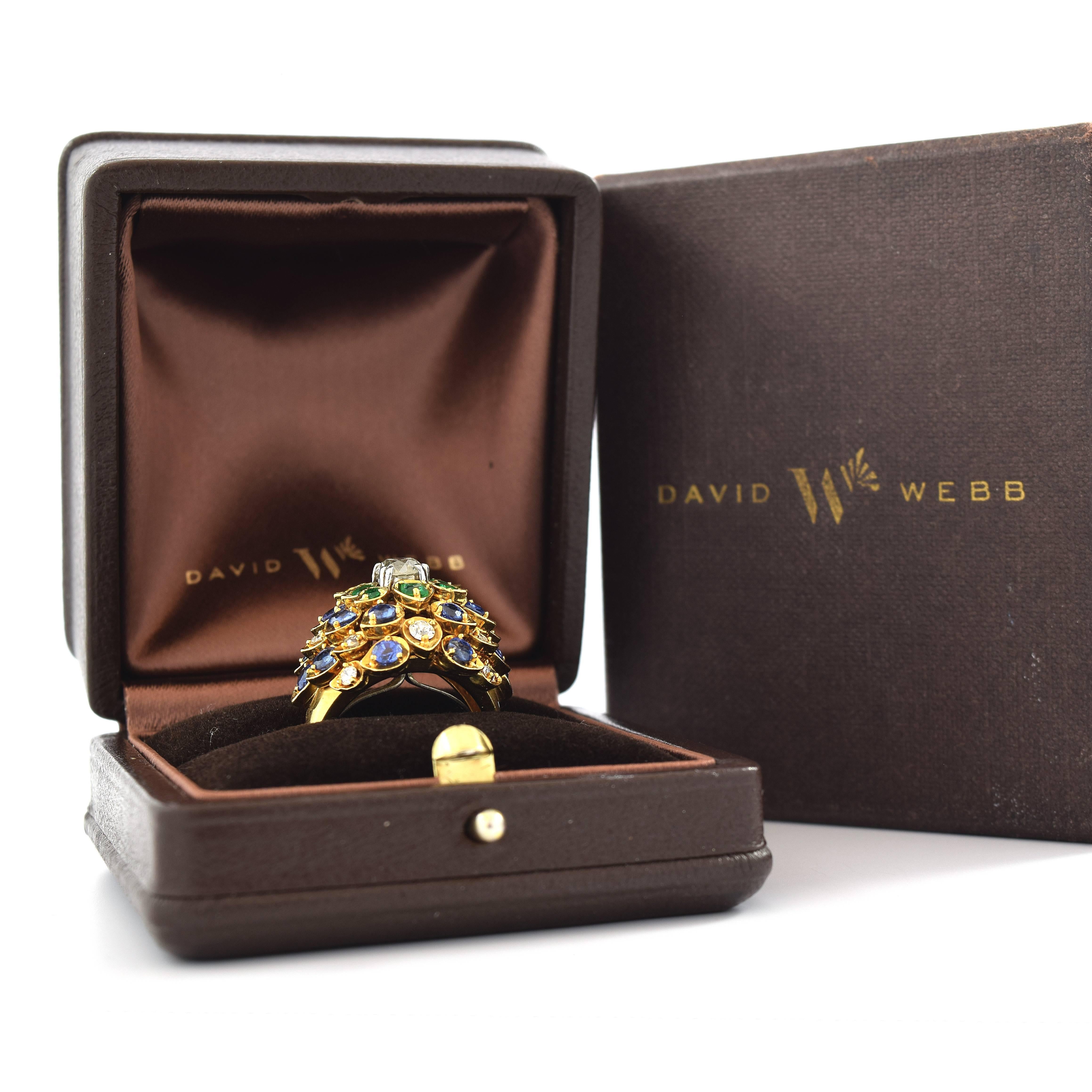 Impressive 18 karat yellow gold cocktail ring, designed by David Webb. 
The center stone is approx ct old mine diamond, surrounded by a cluster of 8 green emeralds, 18 blue sapphire and 12 diamonds.
stamped 