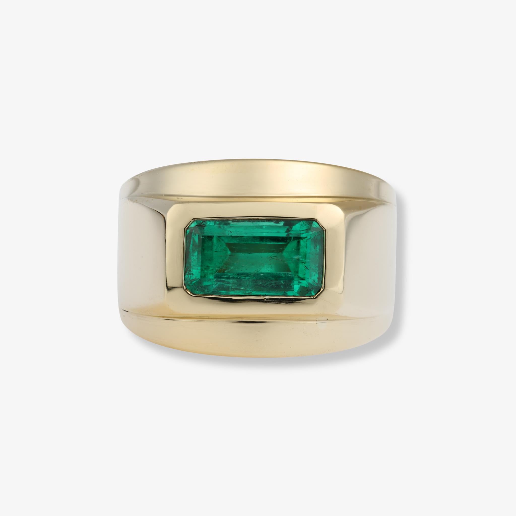 Une fine émeraude verte de Colombie est sertie au centre de cette importante bague en or jaune 18 carats de David Webb. La pierre taillée en émeraude est présentée dans une large lunette architecturale qui met en valeur sa couleur verte saturée et