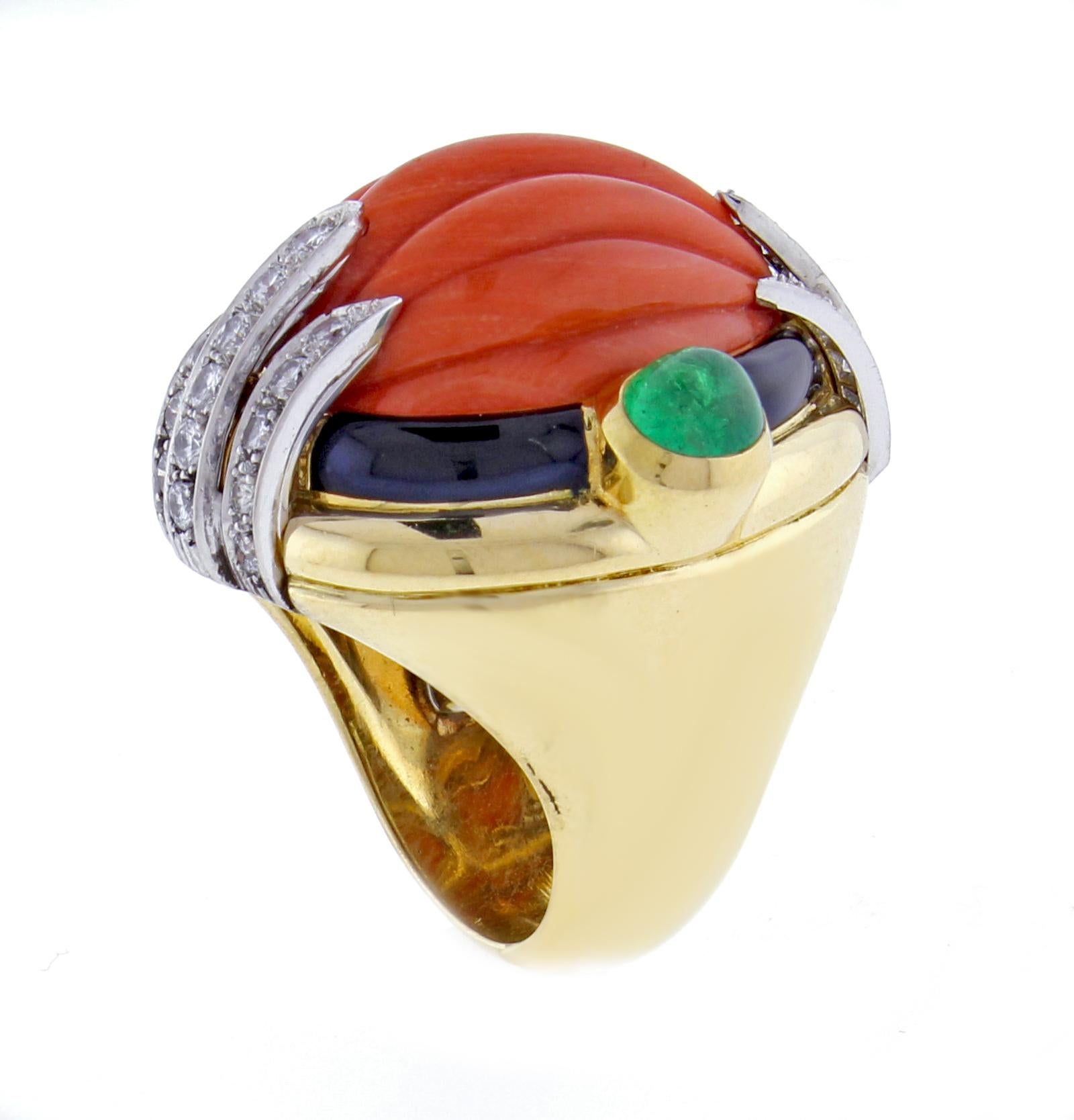 From David Webb, this magnificent carved coral ring.  The ring boasts a center carved salmon coral in a black enamel frame. There are two cabochon emeralds weighing approximately 1.70 carats on ether side and three section of diamonds. The 29