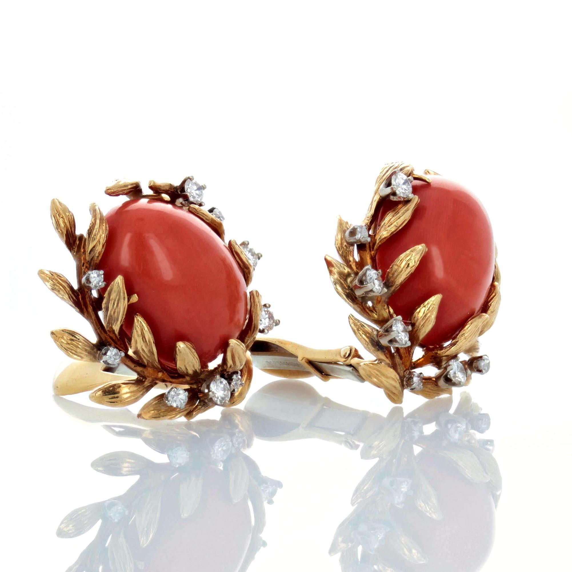 A pair of estate clip earrings centering upon oval-shaped cabochon coral, tucked into a textured 18 karat yellow gold laurel and accented with brilliant-cut diamonds. Signed Webb for David Webb. These earrings have acquired a nice patina which