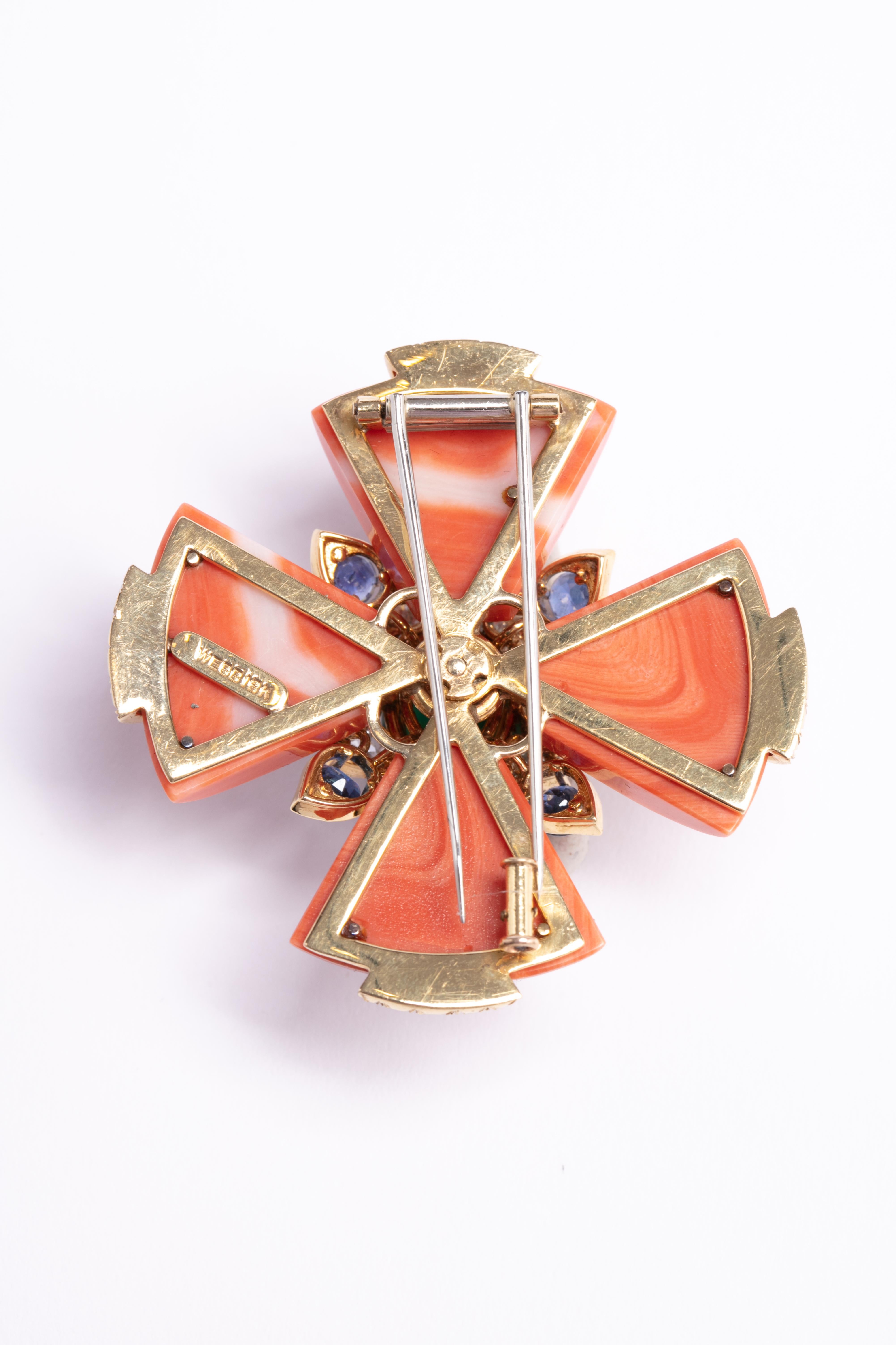 Iconic David Webb coral Maltese cross pendant with diamonds and sapphires surrounding a gorgeous emerald in the center of this show stopping pendant / brooch.
4 individual pieces of coral with 4 well colored sapphires and 84 diamonds surrounding the